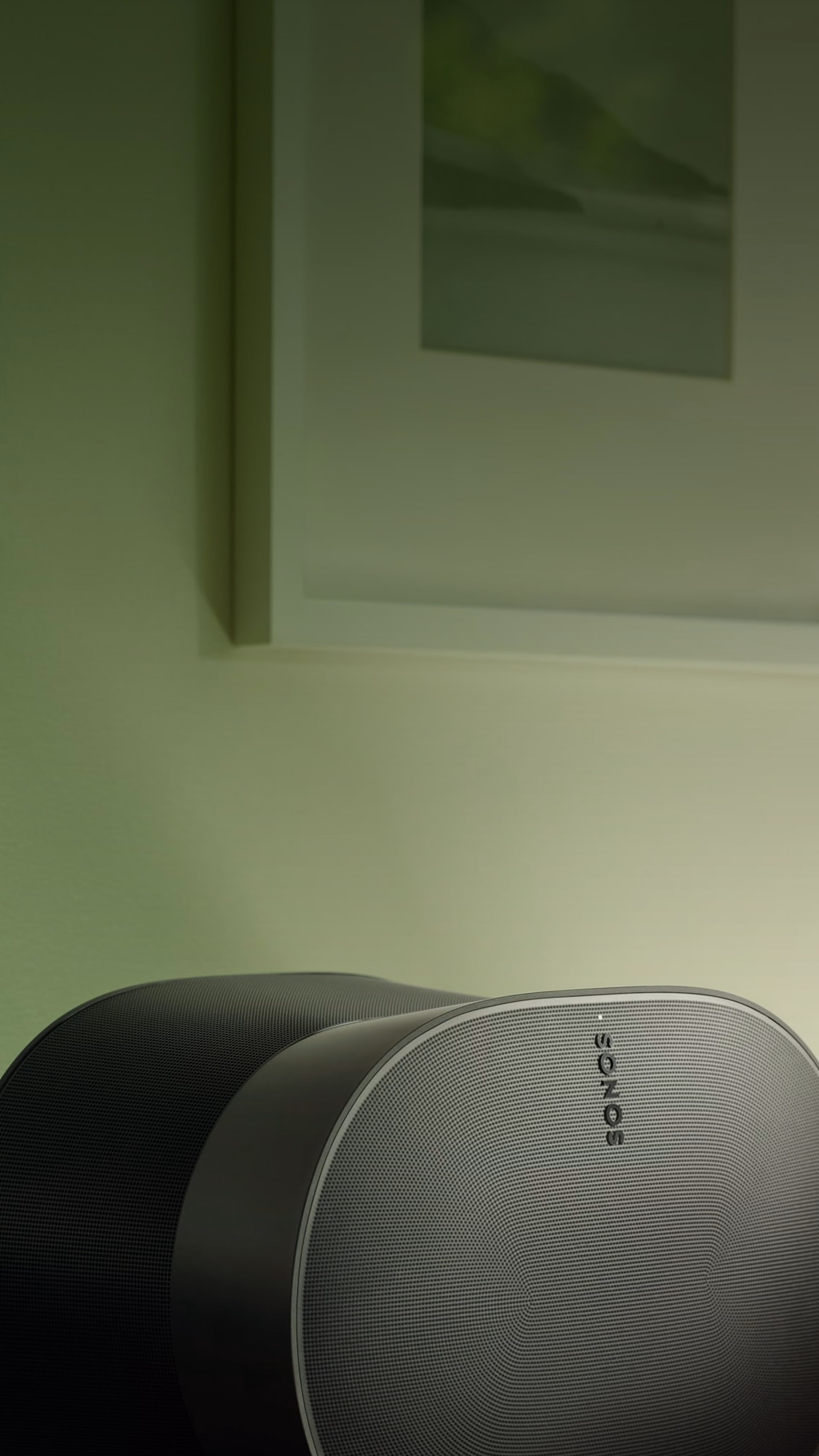 Une enceinte Sonos Era 300 noire sur une table, éclairée par une ampoule verte Philips Hue