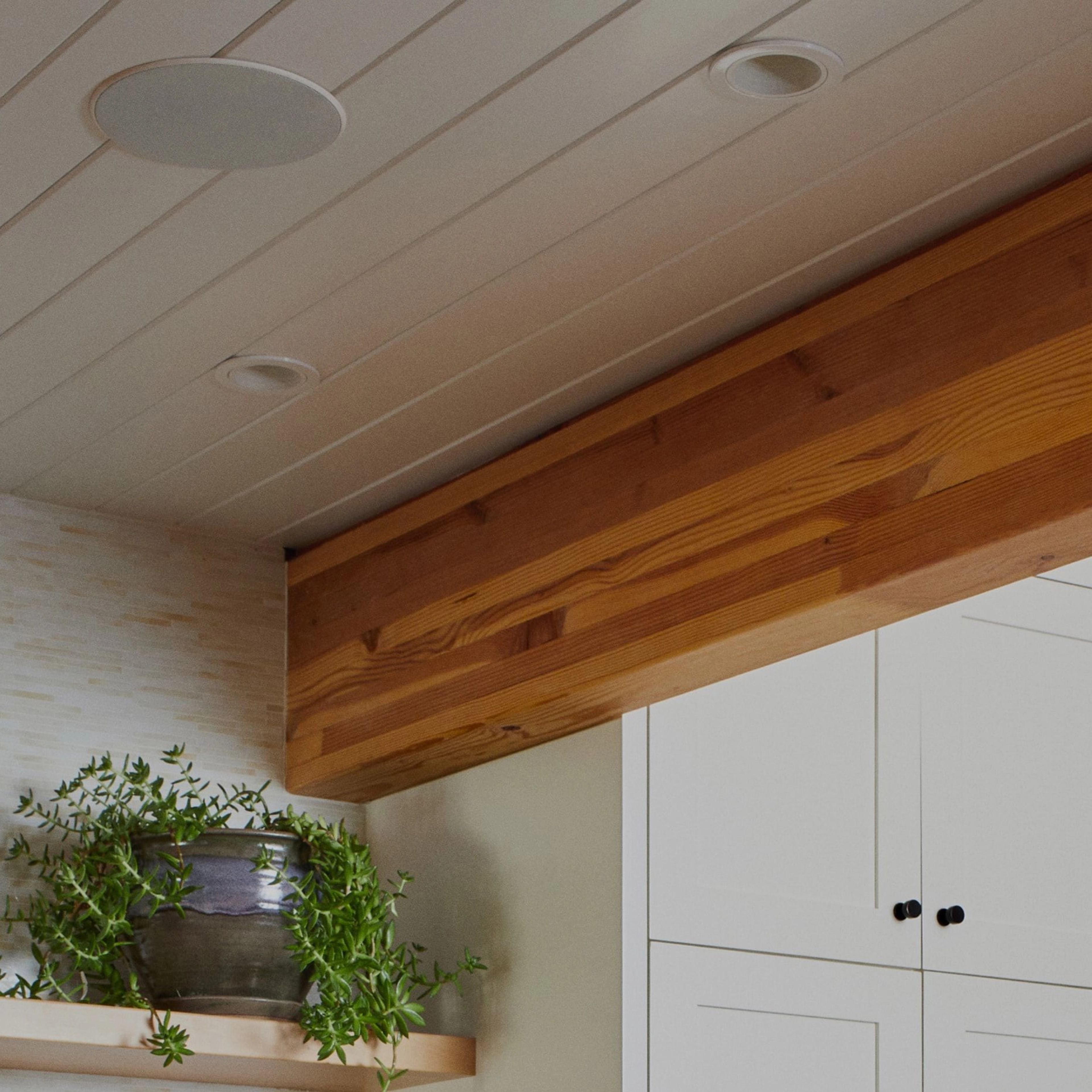 Close-up van In-Ceiling-speakers van Sonos en Sonance geïnstalleerd in plafond boven stellingkast