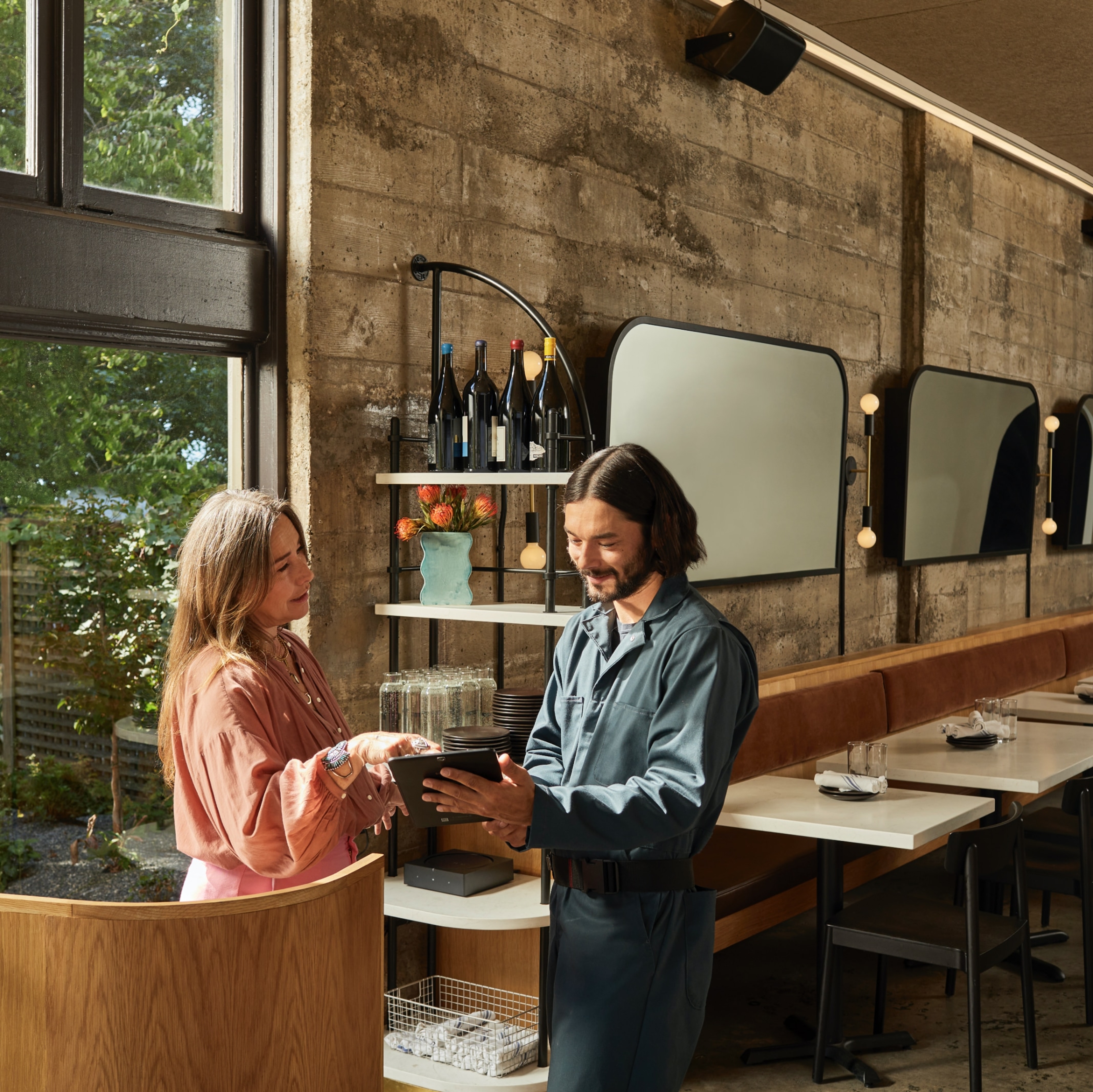 Two people looking at a tablet inside a restaurant