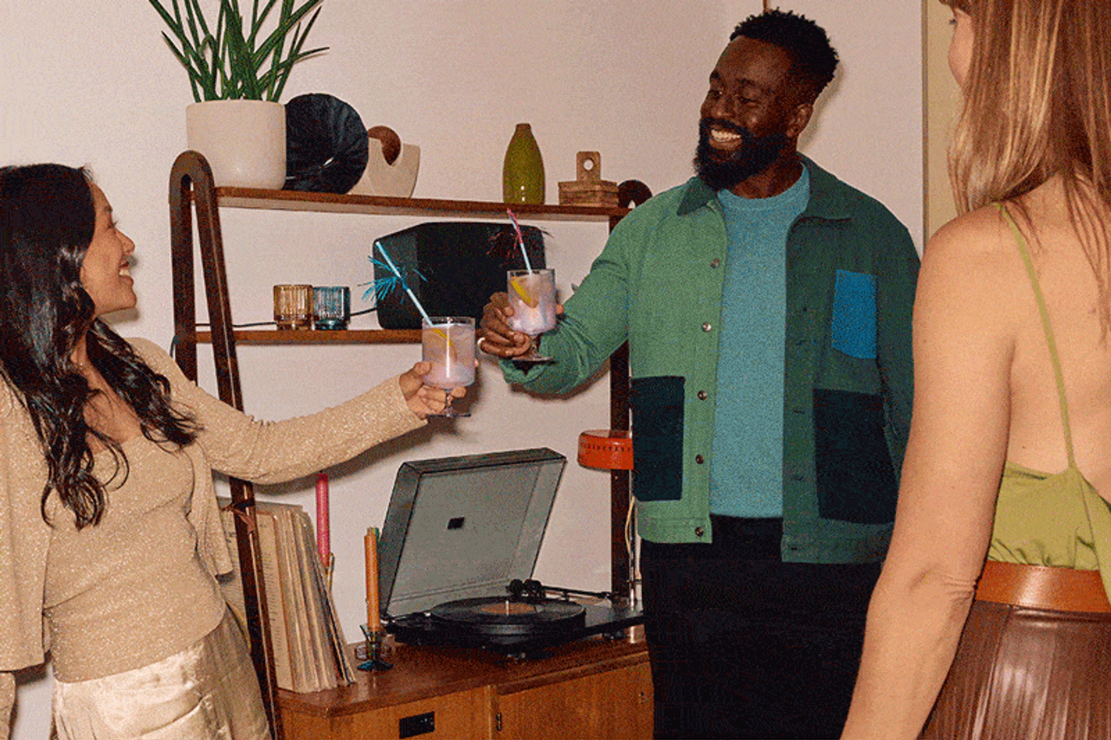 A group of friends at a holiday party drinking cocktails and listening to vinyl on a Sonos Five