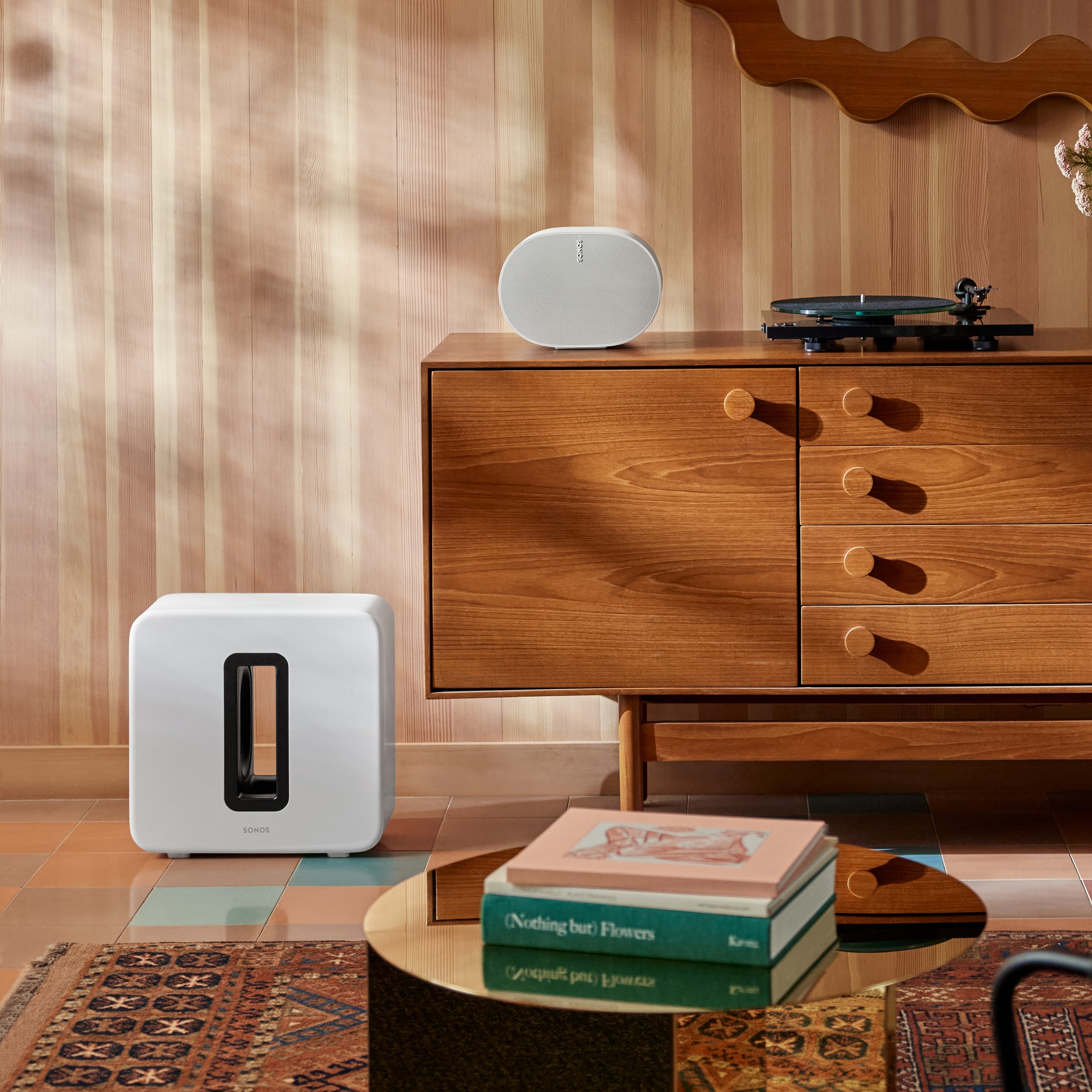 A white Sub 4 next to a credenza with a white Era 300 and a turntable on top