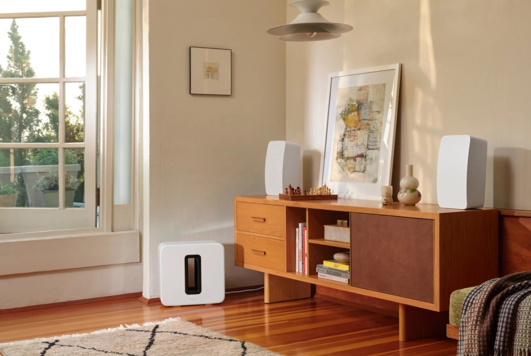 Subwoofer Sonos Sub en una elegante sala de estar, junto a un sofá.