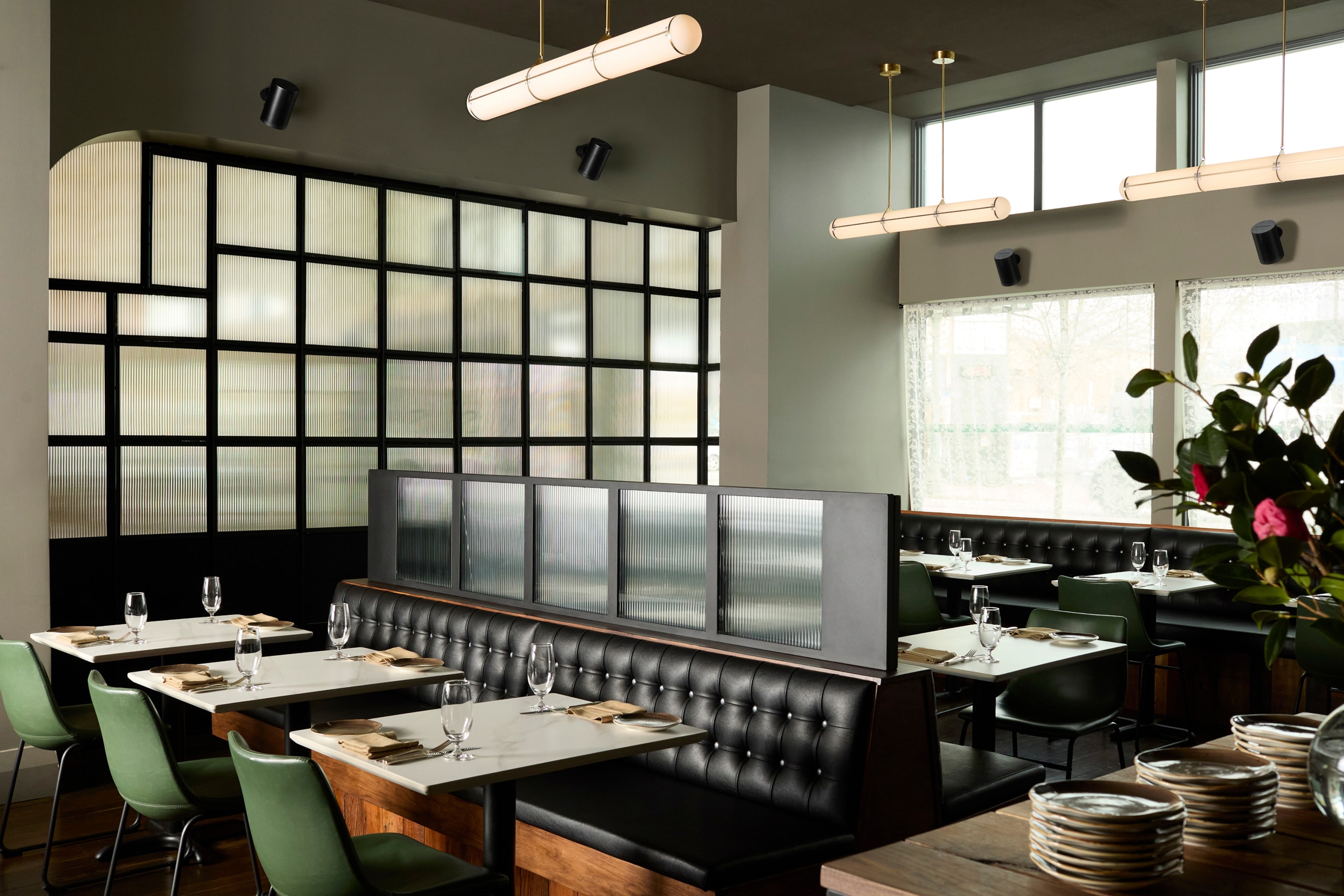 A restaurant interior with wall-mounted Era 100 Pro speakers