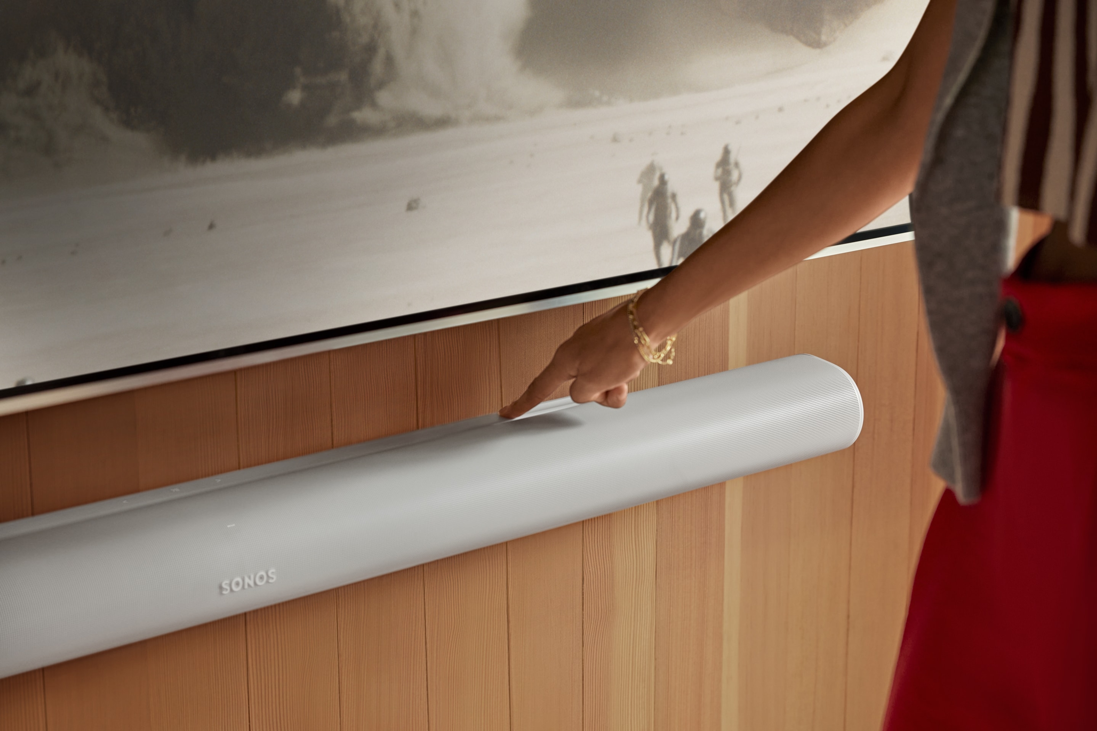 User engaging with the touch controls on a wall-mounted, white Arc Ultra