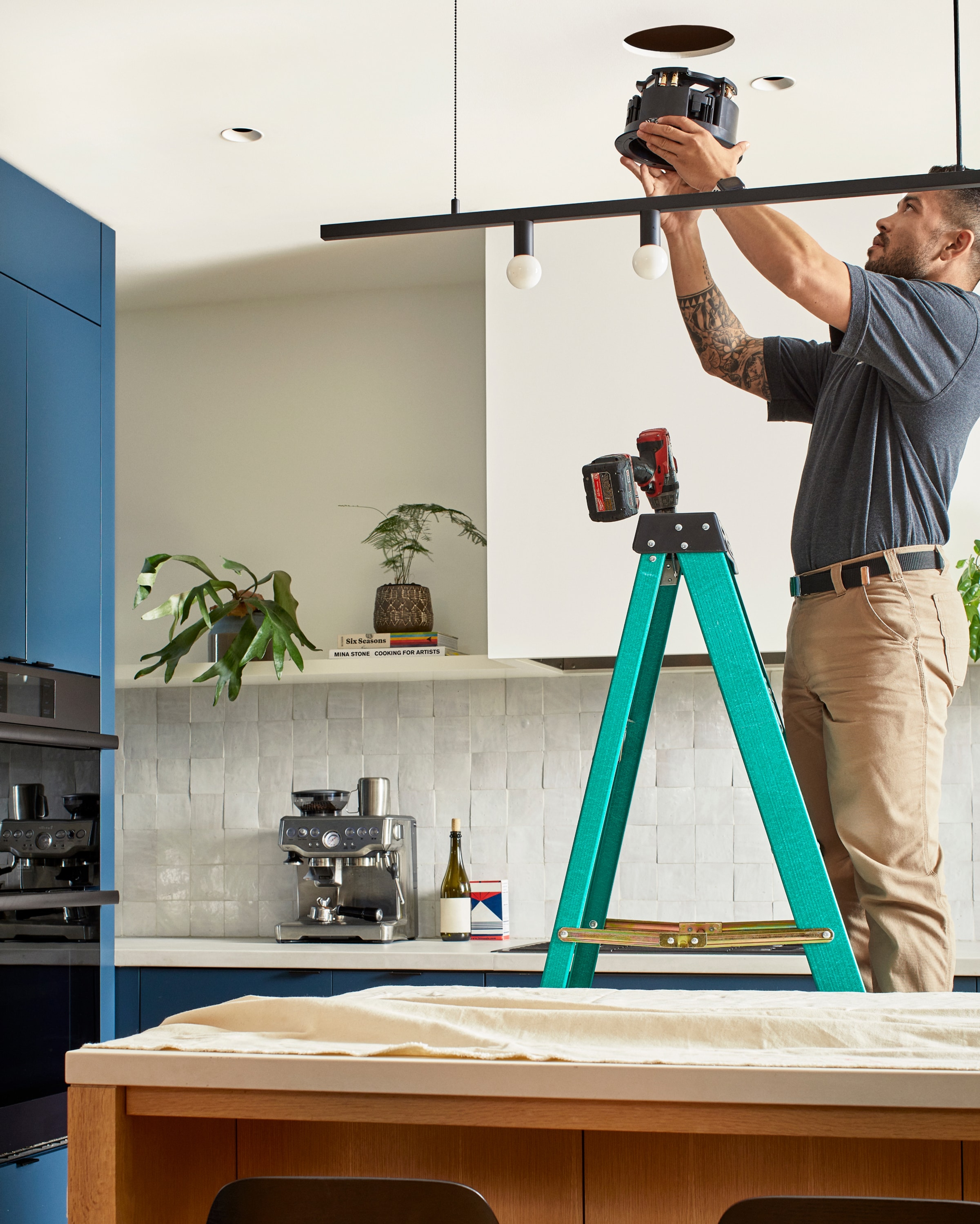 Professionele installateur die In-Ceiling-speakers van Sonos en Sonance installeert boven een keukeneiland