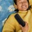 Sonos user in a yellow sweater lying on a blue blanket enjoying the sound of a Roam 2 portable speaker