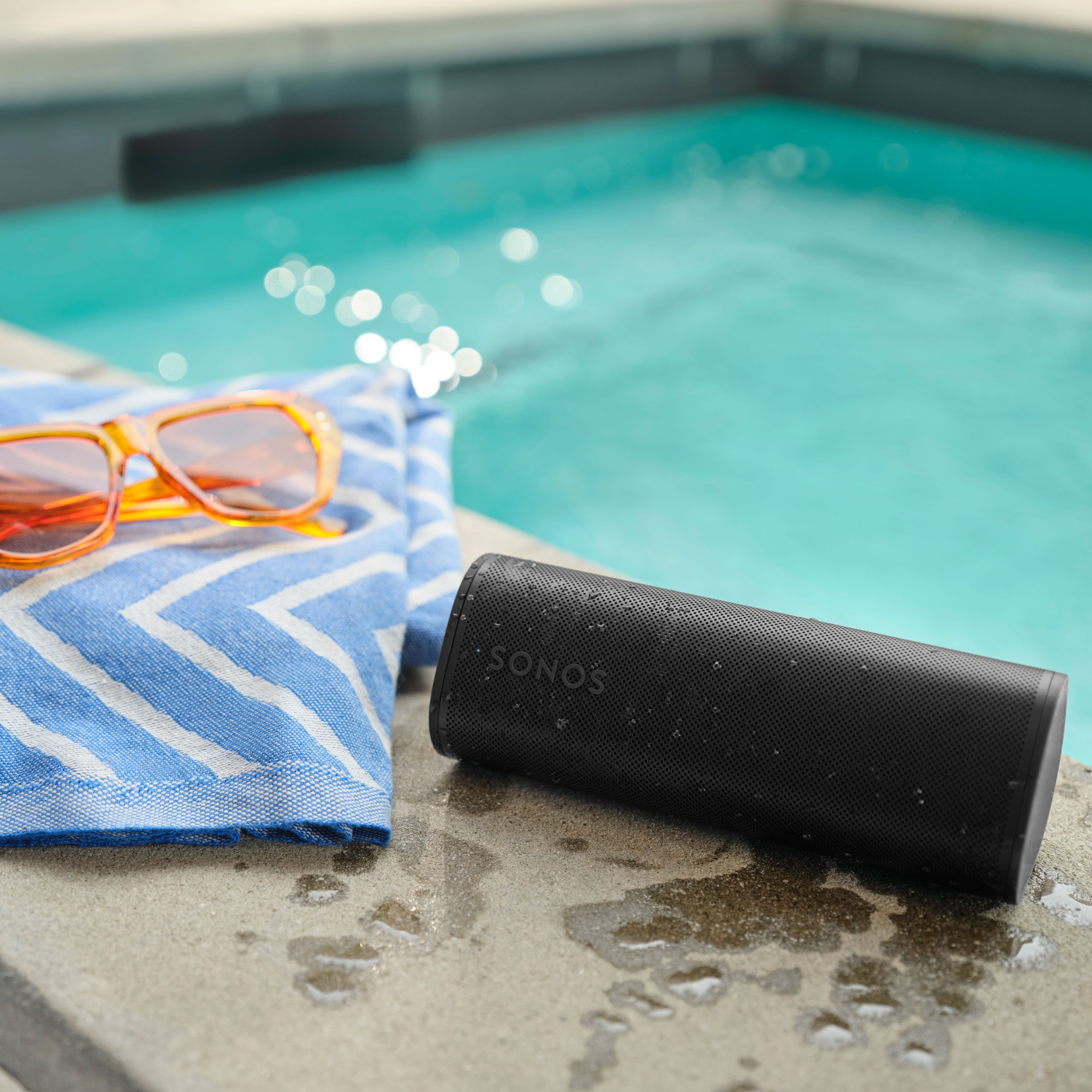 Sonos Roam 2 Noir au bord de la piscine avec une serviette