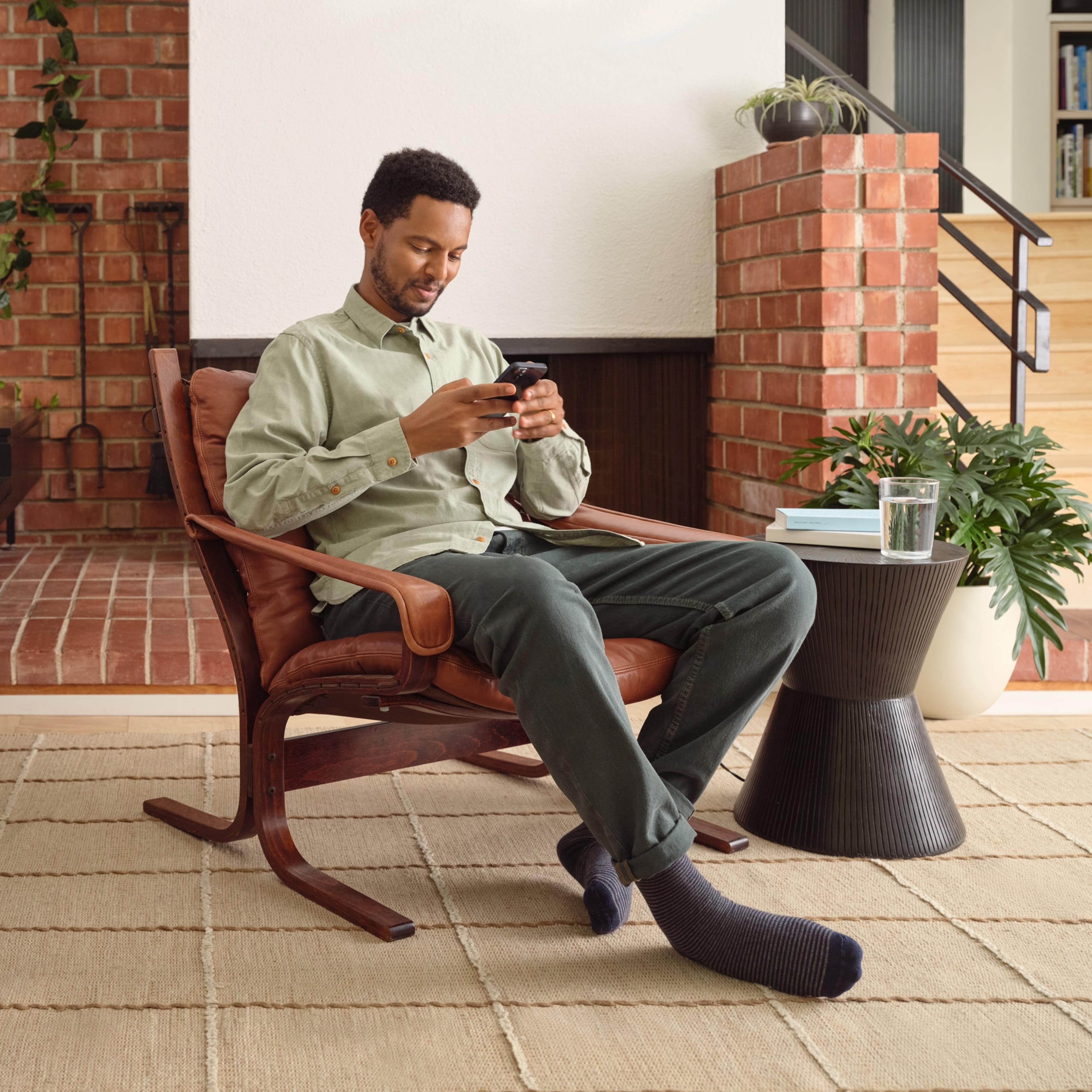 Sonos user seated, controlling Sonos on his phone