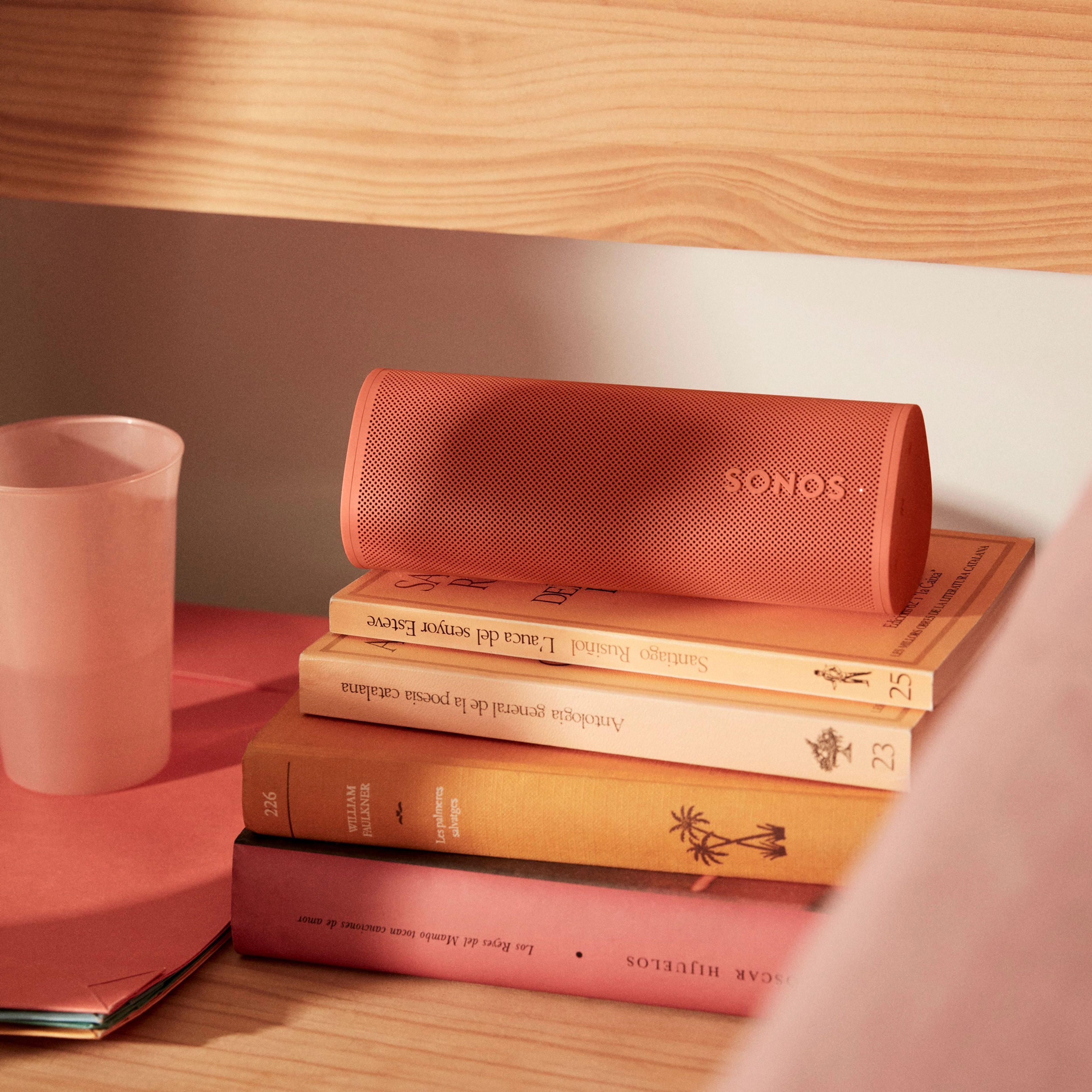 Sonos Roam 2 in Sunset on top of books