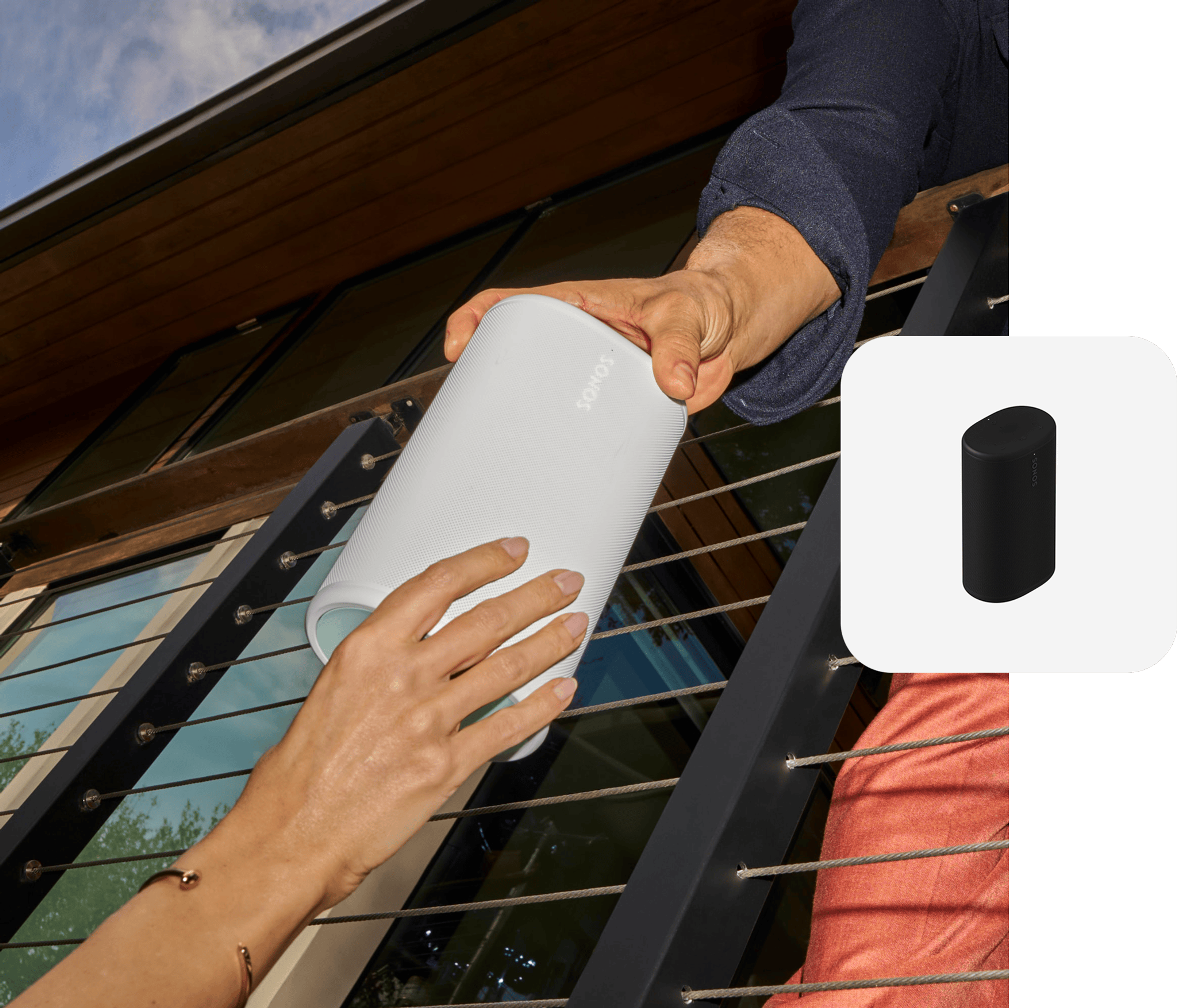 Closeup of two hands passing off a white Sonos Play speaker