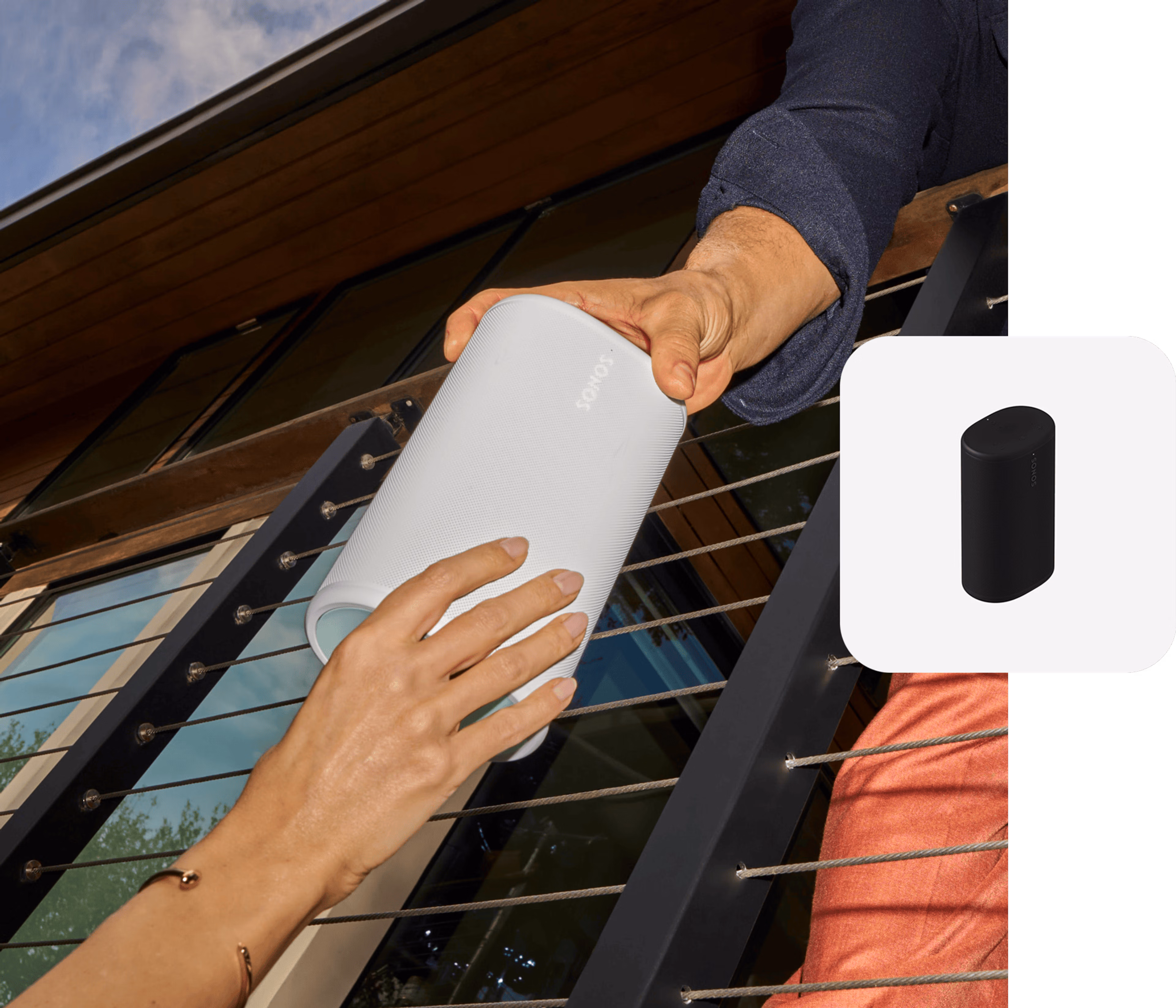 Closeup of two hands passing off a white Sonos Play speaker