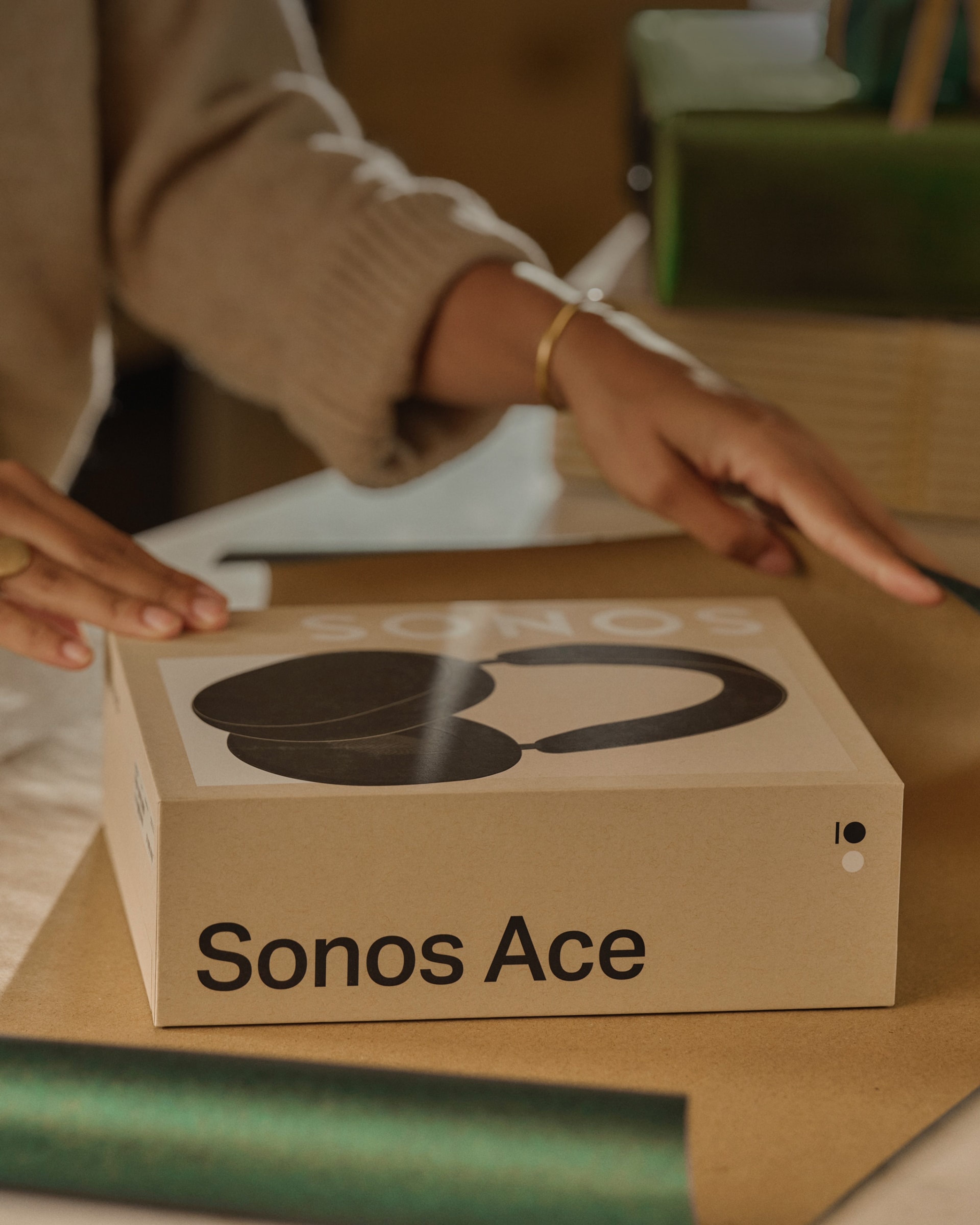 Person gift wrapping a Sonos Ace headphones