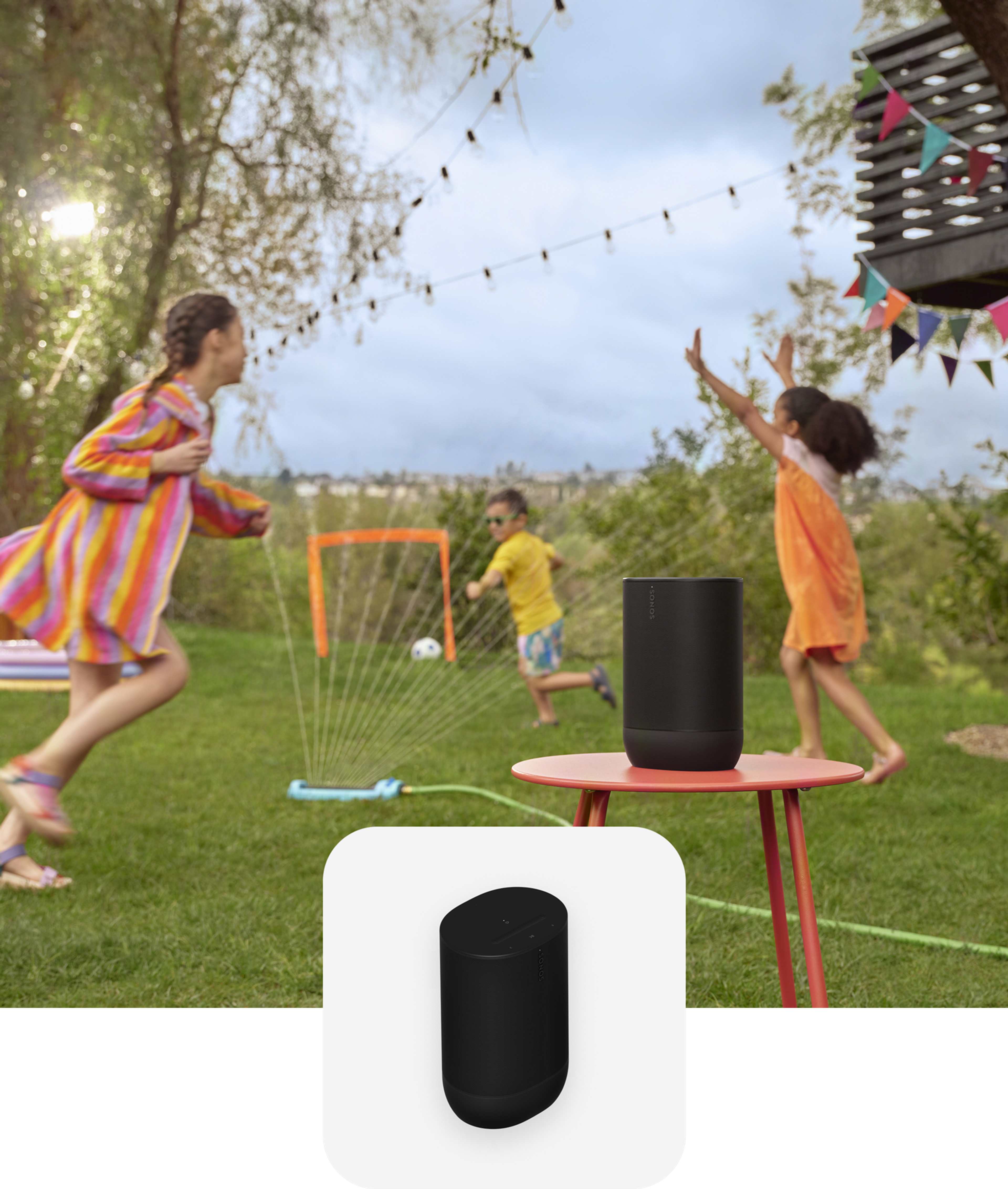 A black Move 2 on a red table while kids play on the lawn in the background