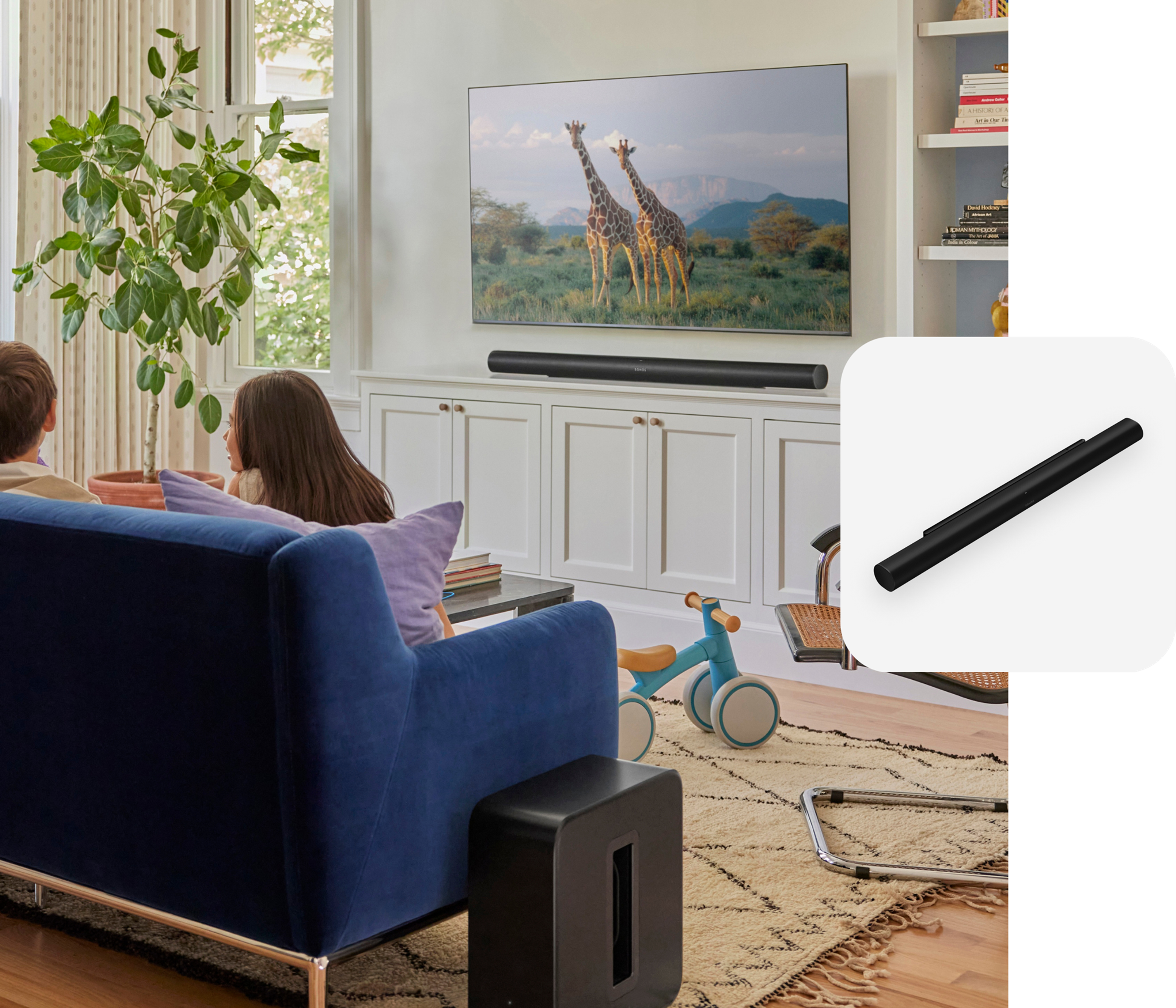Kids sitting on a blue couch in the living room with black Sonos Sub 4 and Arc Ultra and a black Arc Ultra product tile overlay