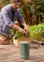 Image of a man gardening knelt beside an Olive Sonos Move 2
