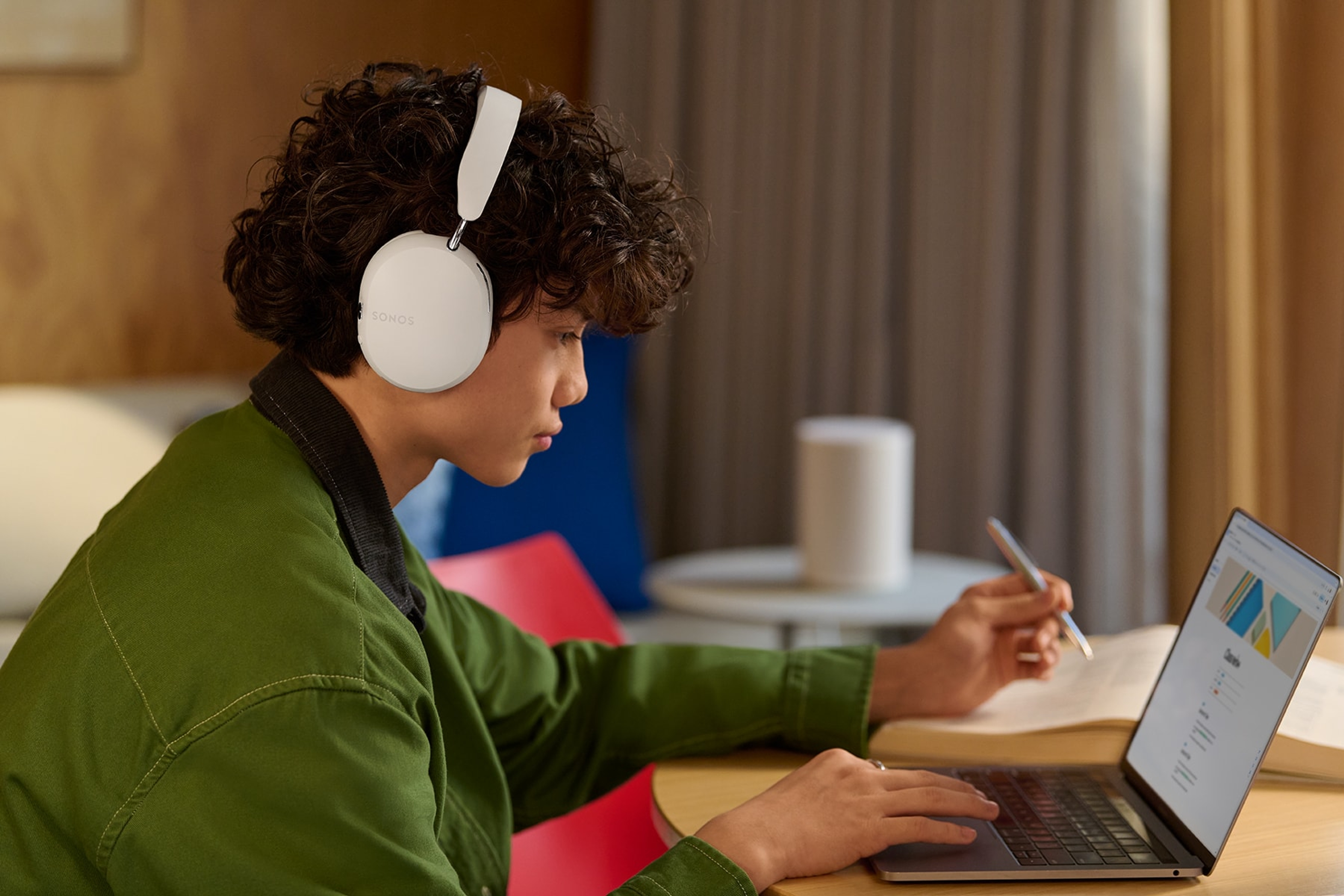 Student wearing Sonos Ace headphones and studying on a laptop