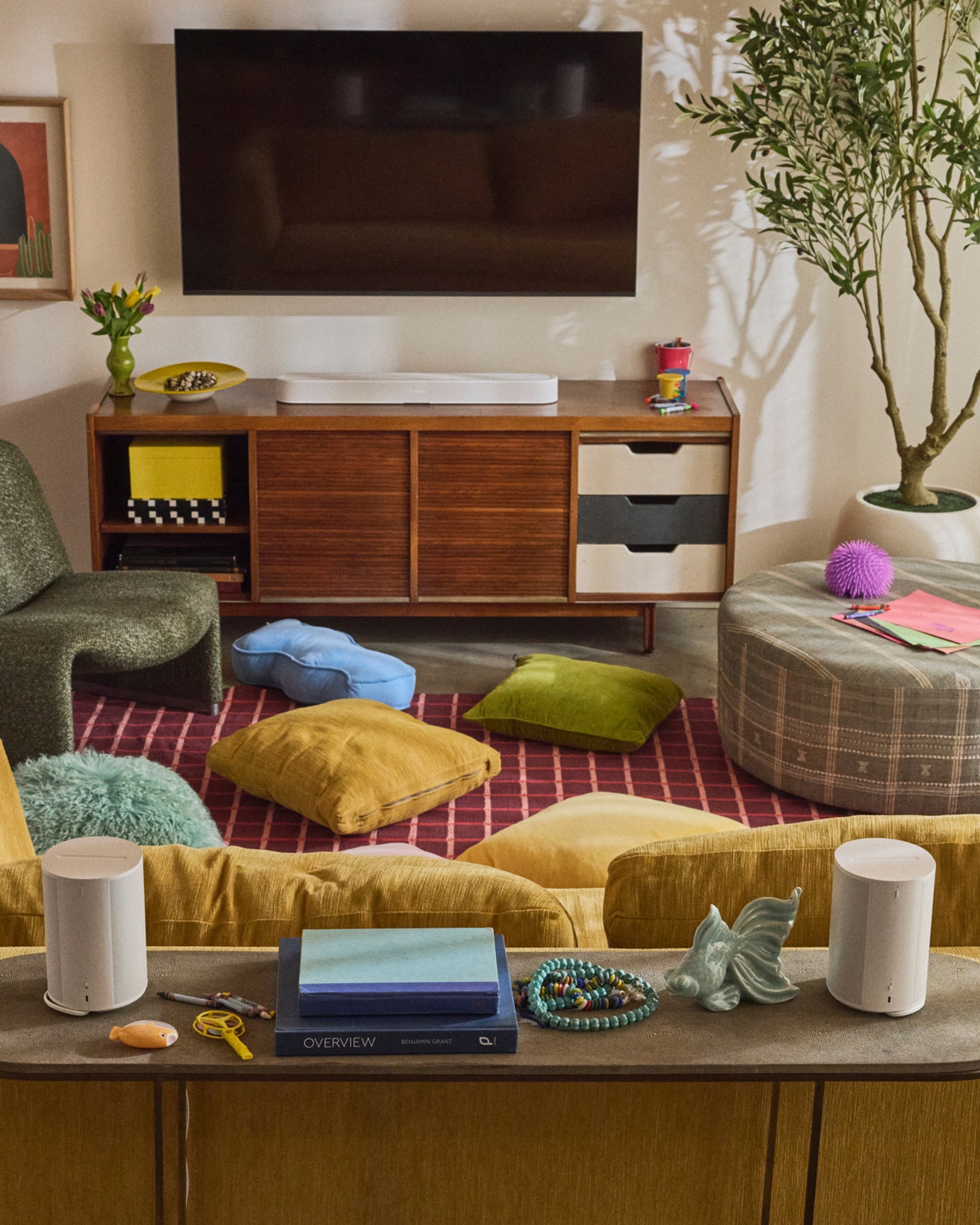 Pair of white Era 100 speakers on a console table in a colorful living room with a white Beam Ultra on a TV stand