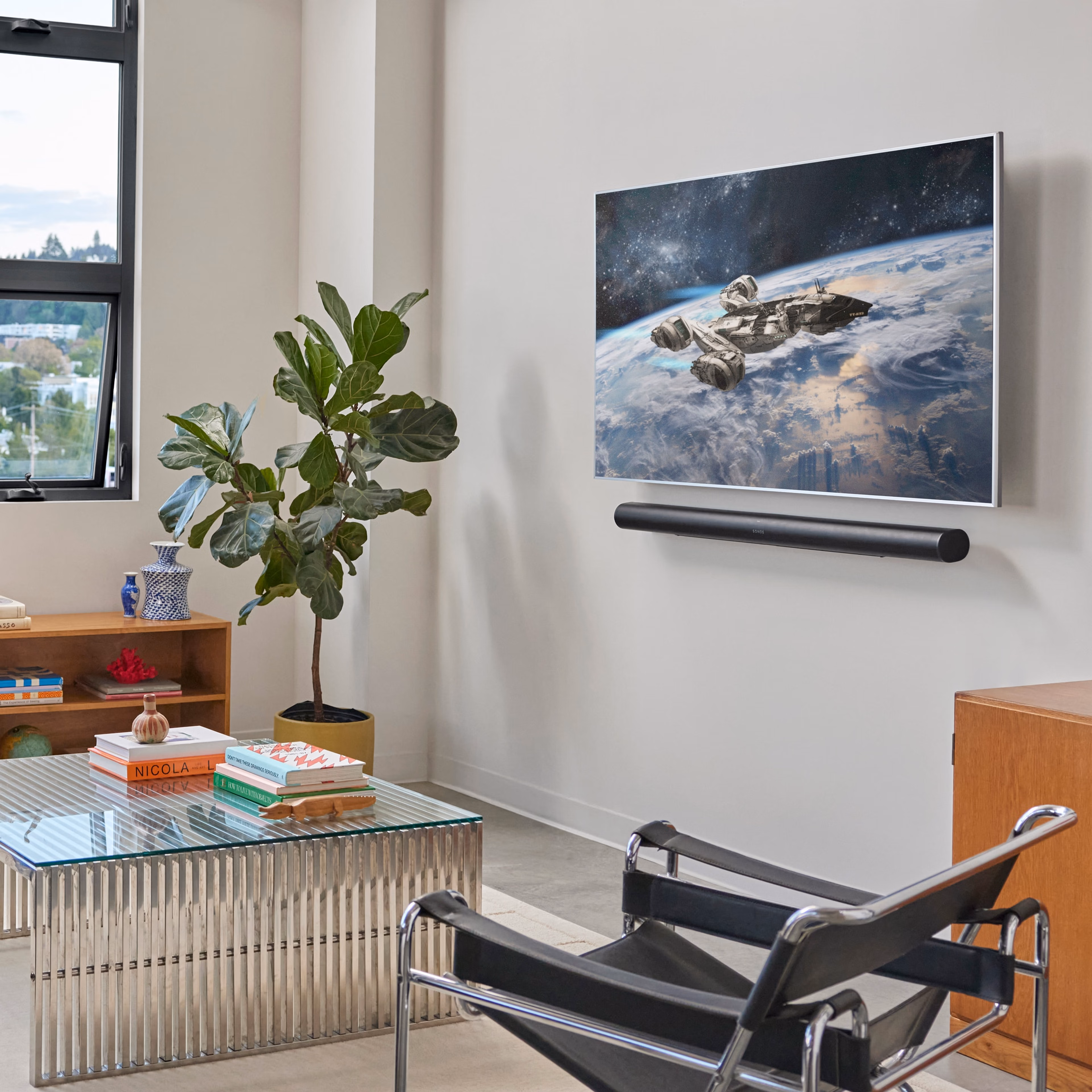 A black Arc Ultra mounted to the wall beneath a TV in a living room