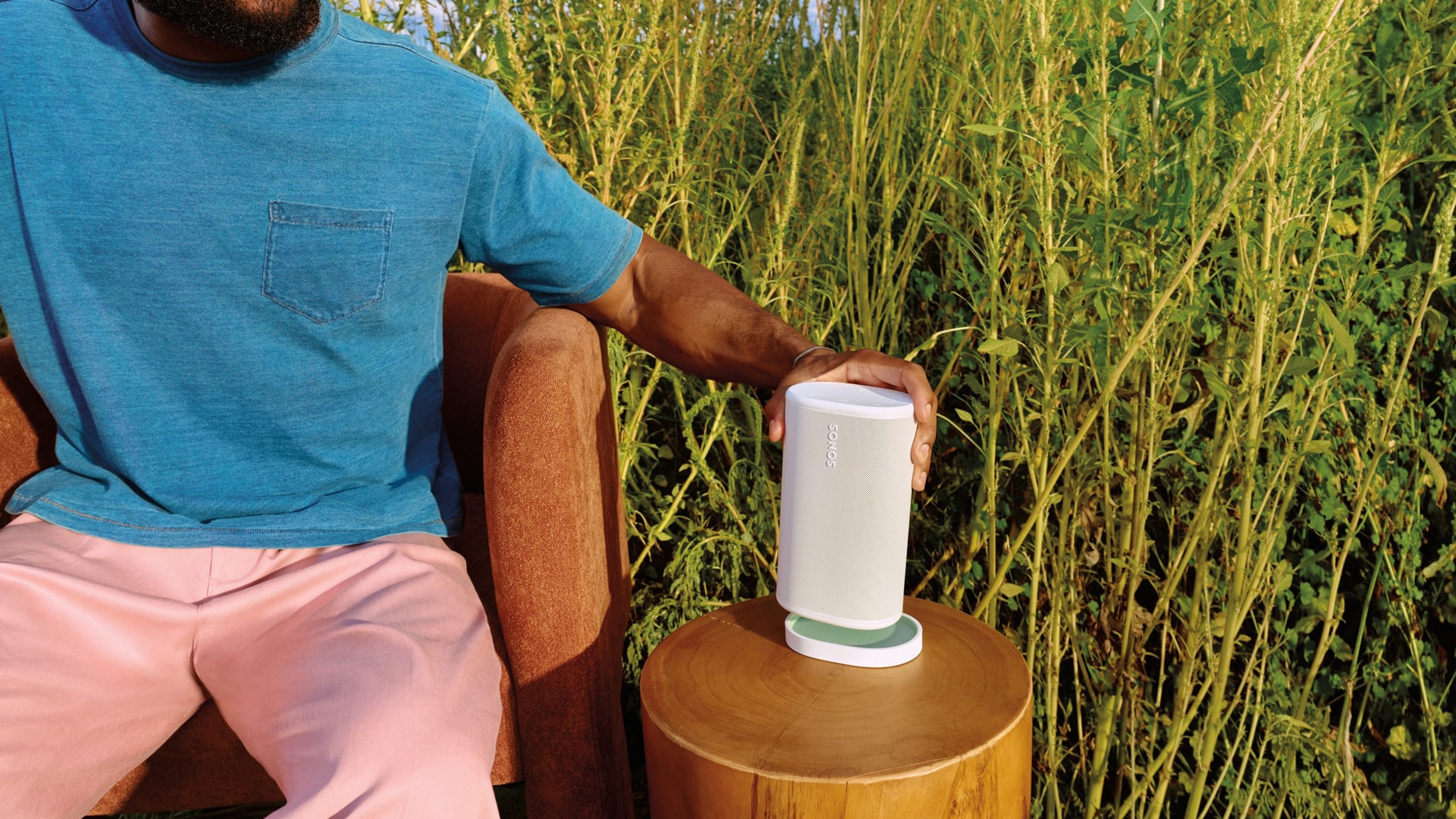 Gebruiker die een witte Sonos Play op een bijpassende oplader plaatst