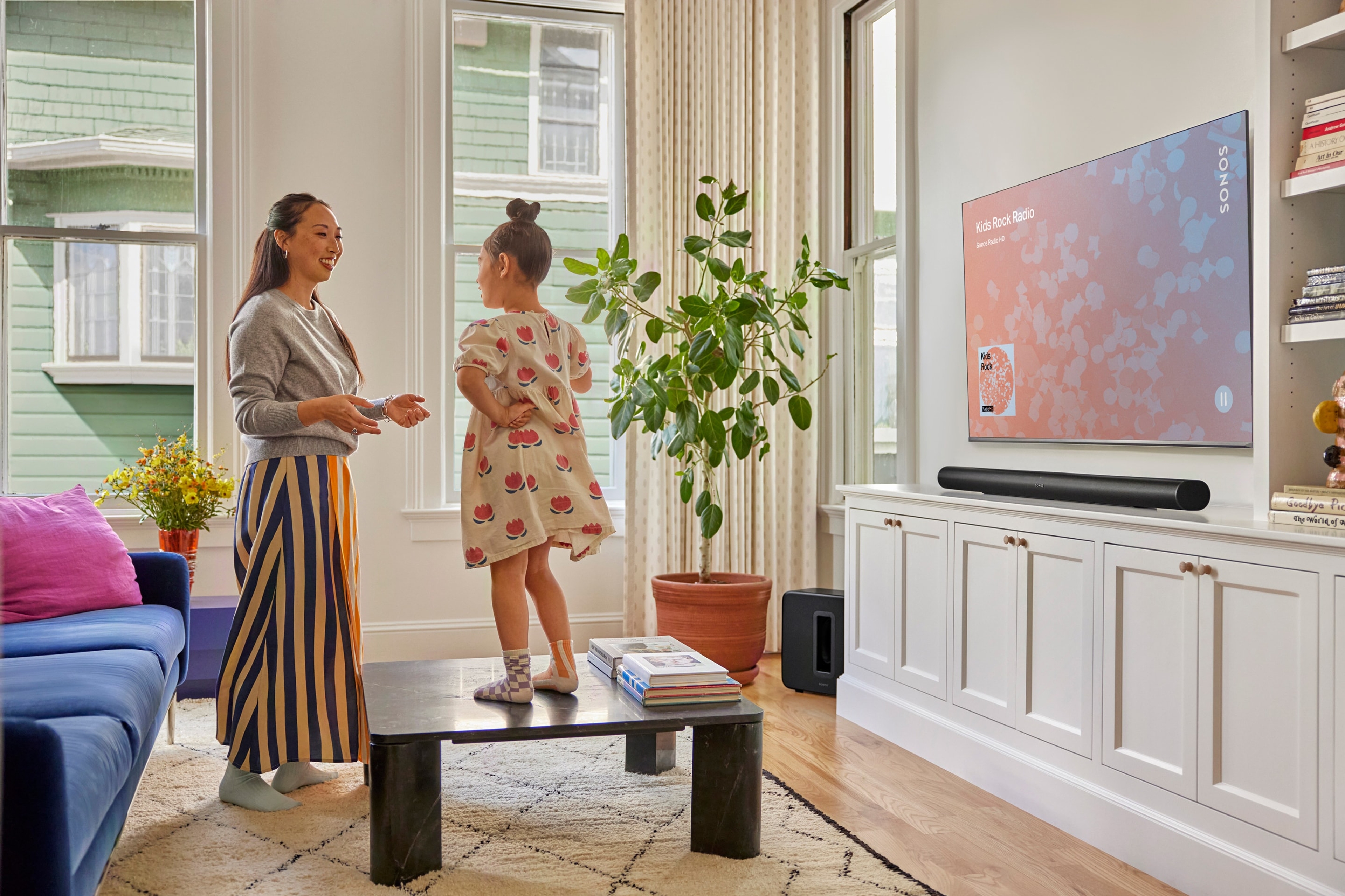 Mother and daughter in the living room listening to Sonos Radio on a black Arc Ultra