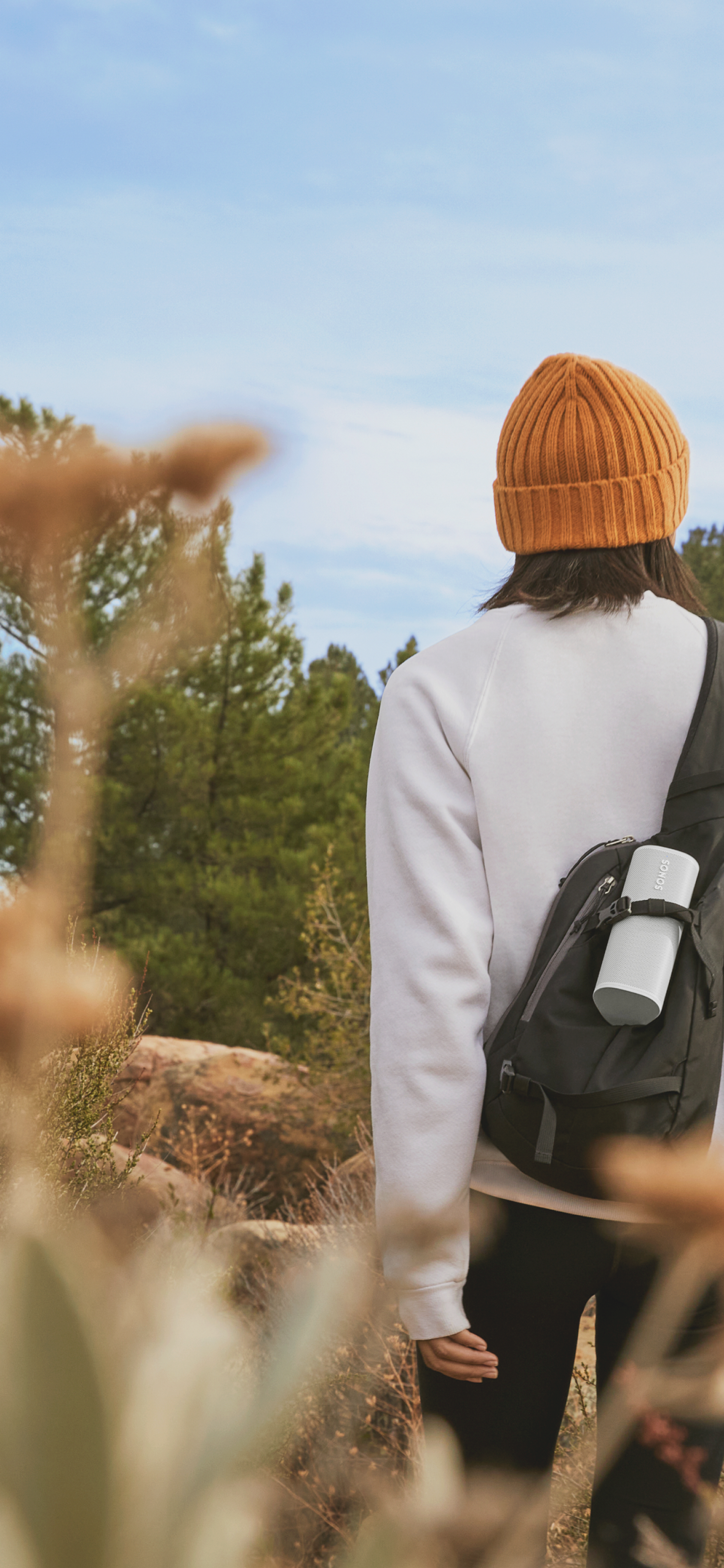 Closeup of Roam speaker in Sunset being carried in a backpack