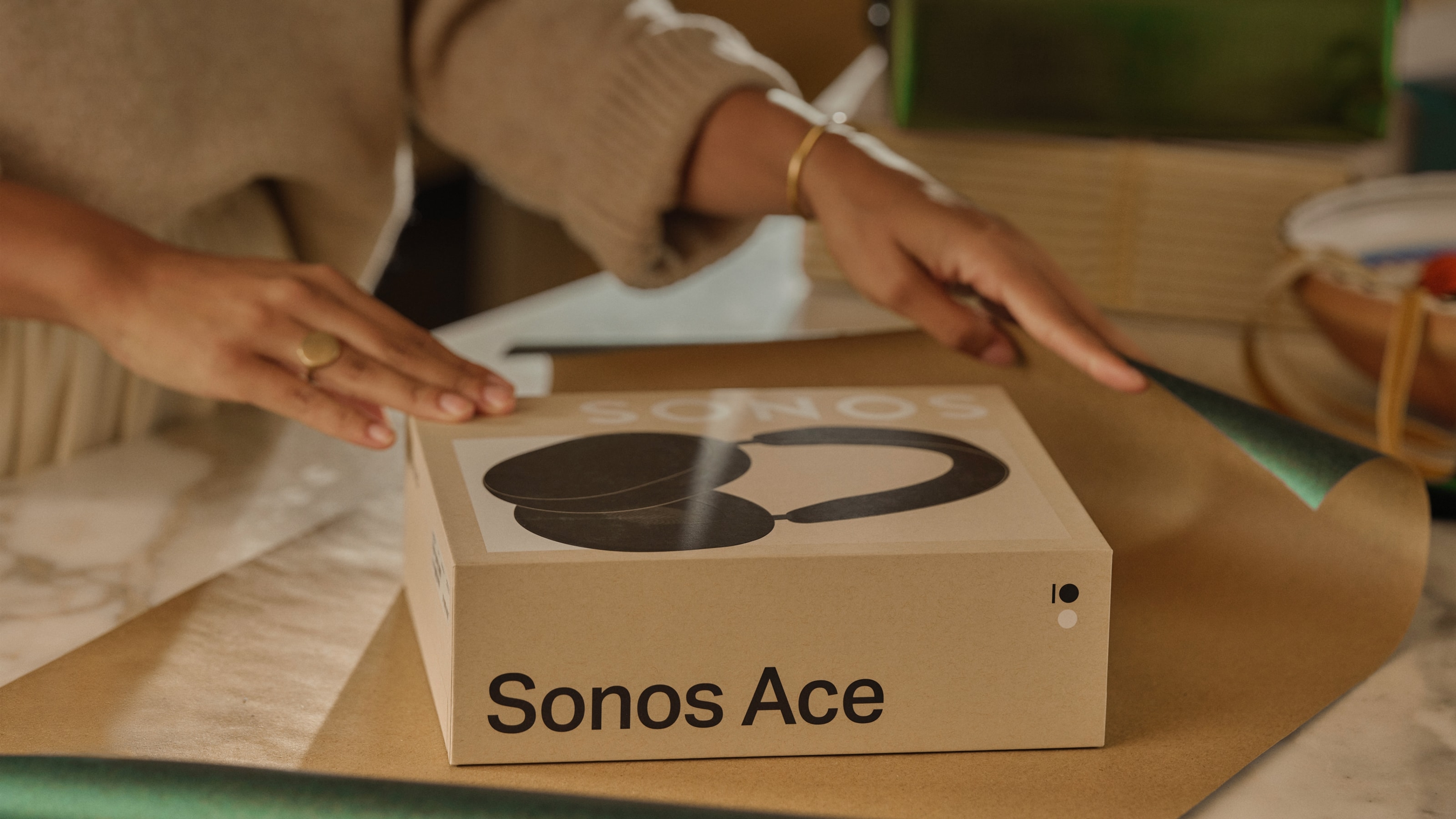 Person gift wrapping a Sonos Ace headphones