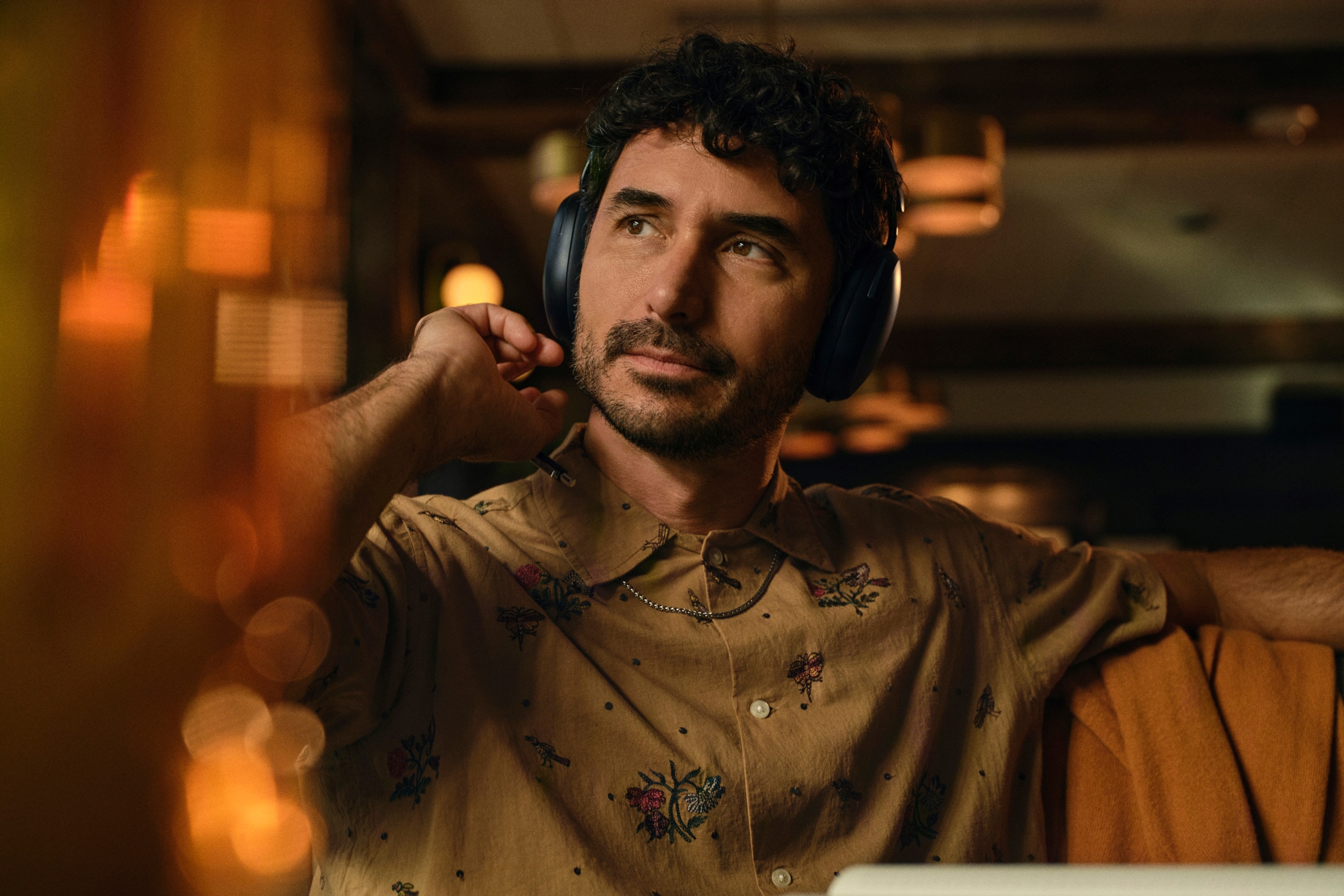 Una persona con unos auriculares Sonos Ace en negro usando el teléfono