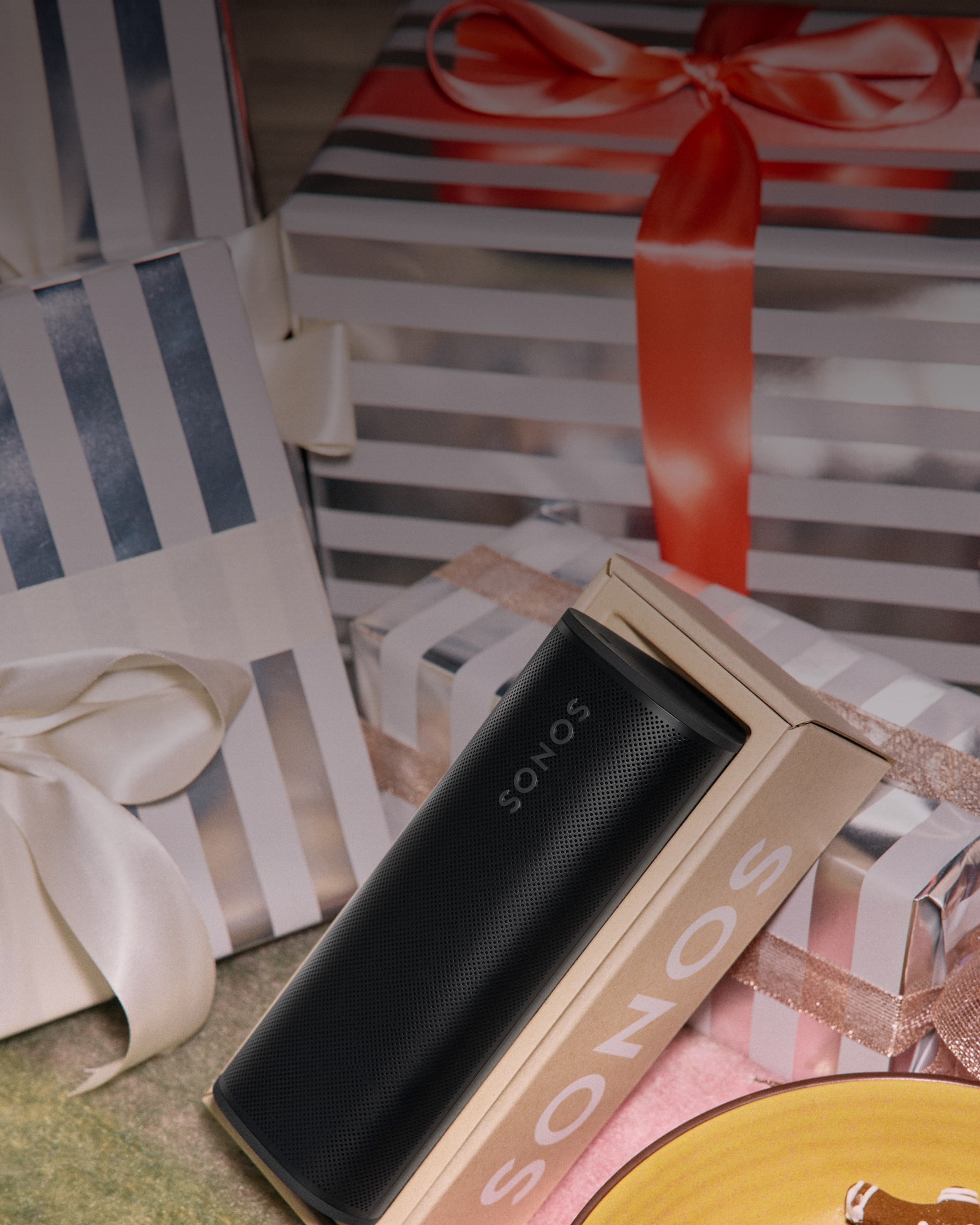 Enjoying holiday gingerbread cookies and unwrapping a black Roam 2 portable speaker