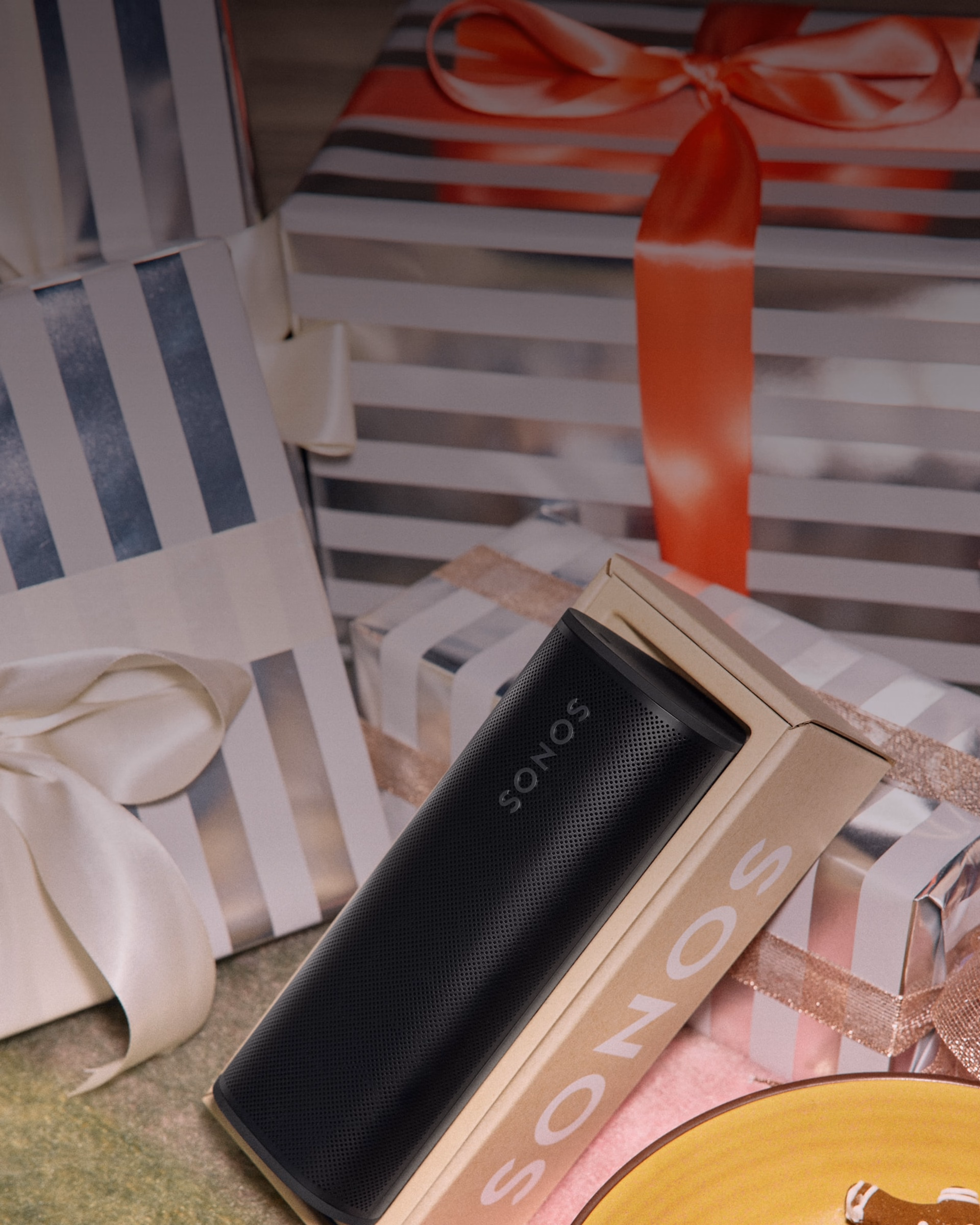 Enjoying holiday gingerbread cookies and unwrapping a black Roam 2 portable speaker