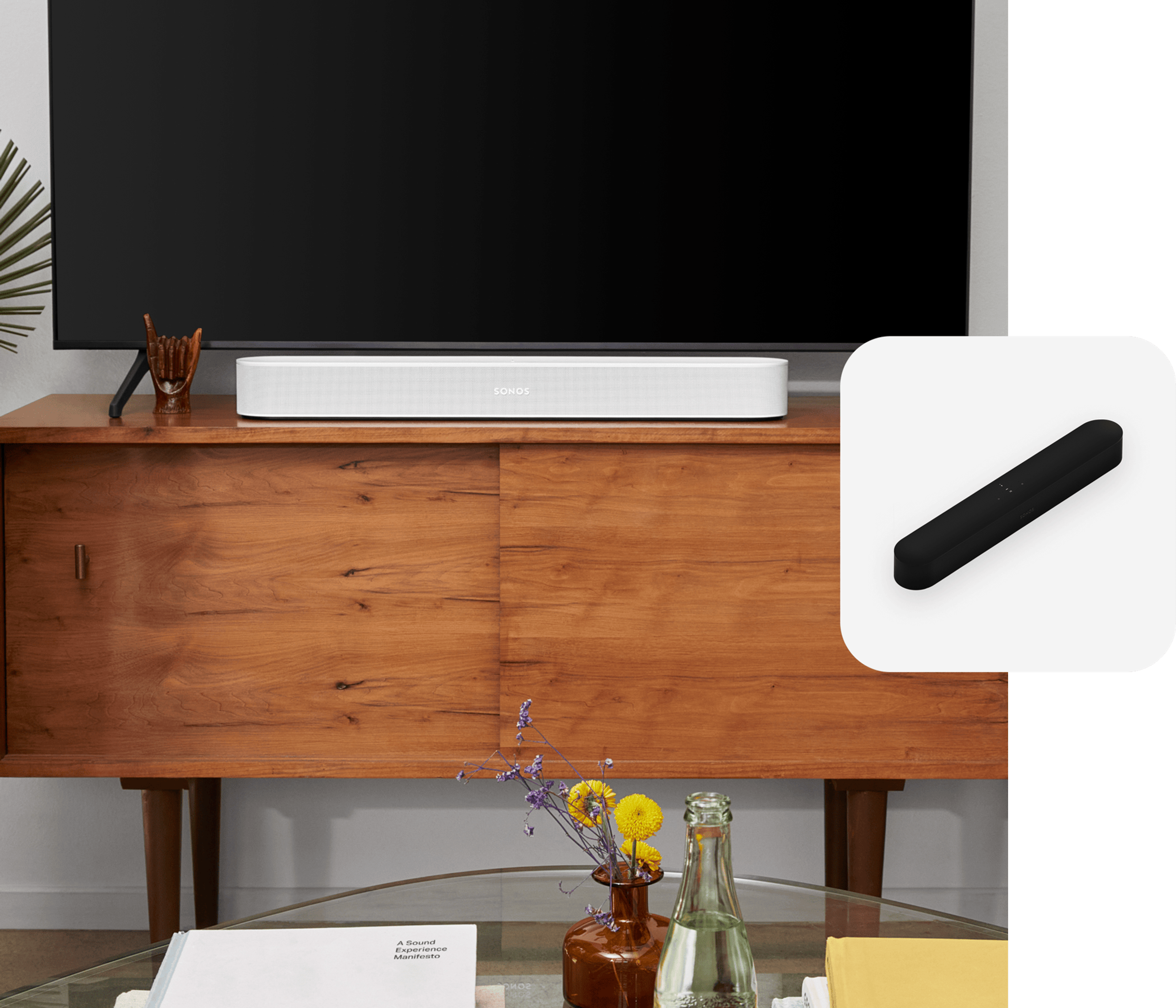 A white Sonos Beam soundbar on a media console below a TV