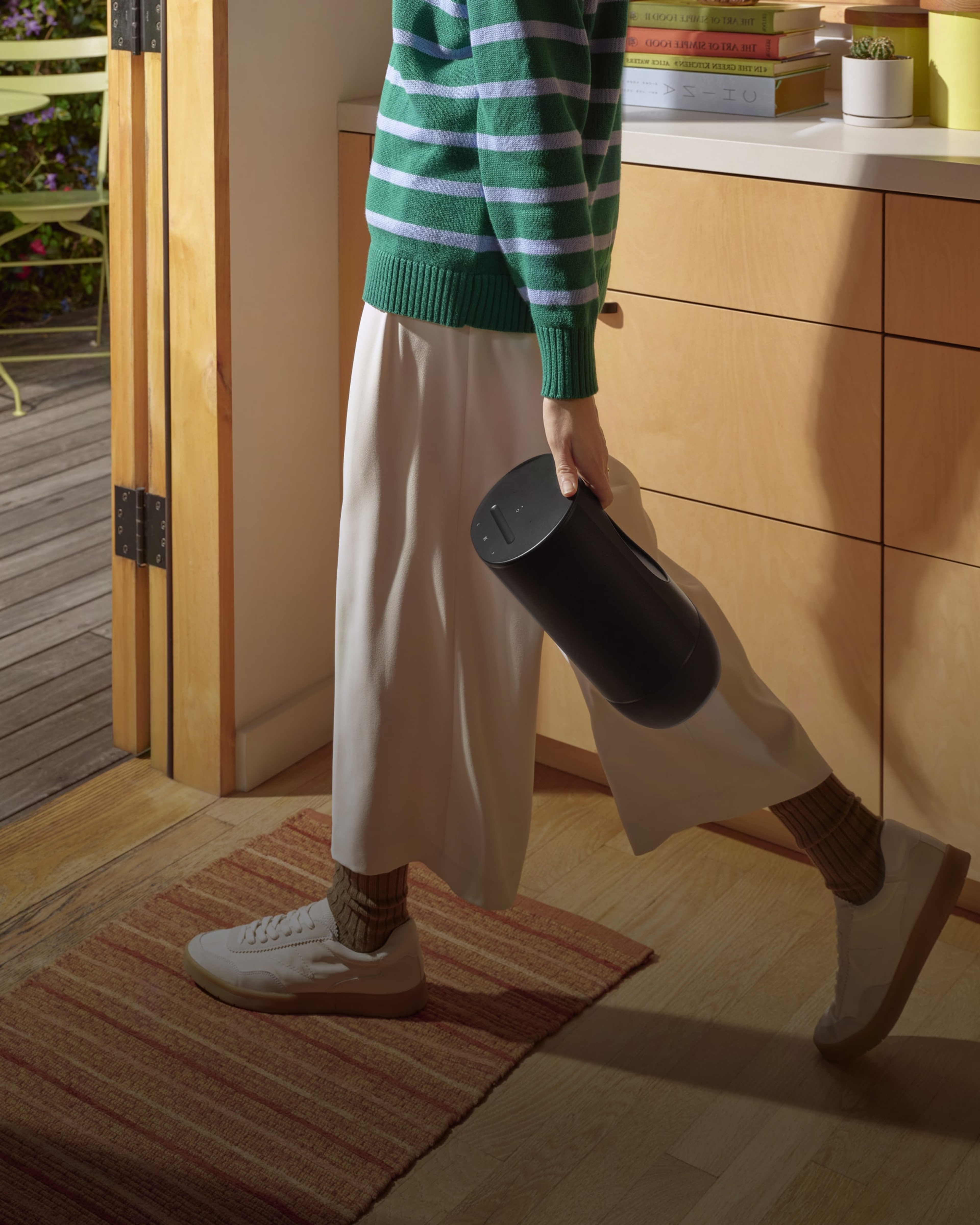 Sonos Move 2(ブラック)を持って外を歩いている人