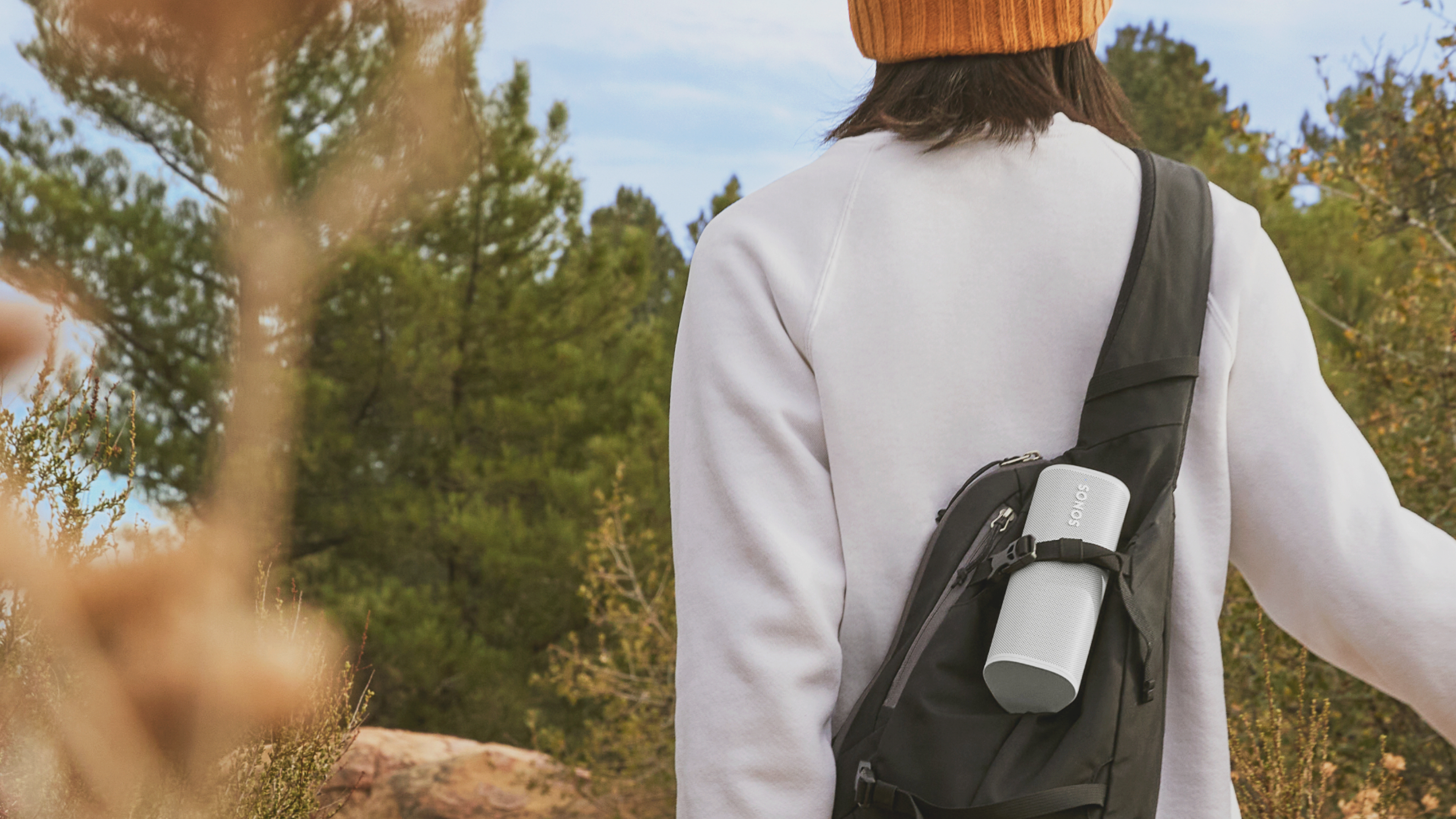 Closeup of Roam speaker in Sunset being carried in a backpack