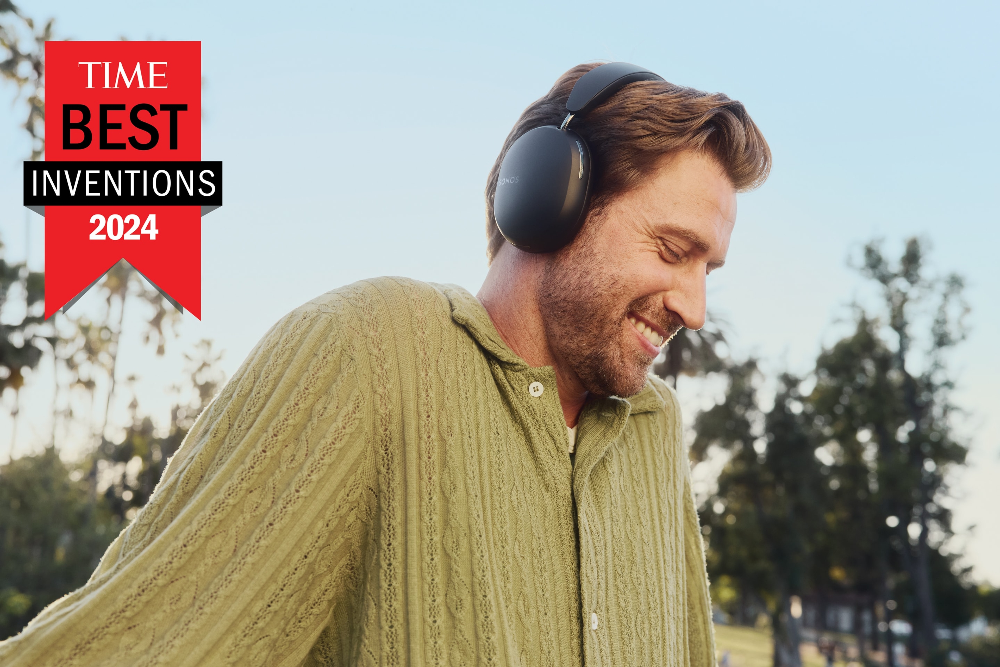 Un usuario que lleva puestos audífonos Sonos Ace en color negro en el parque