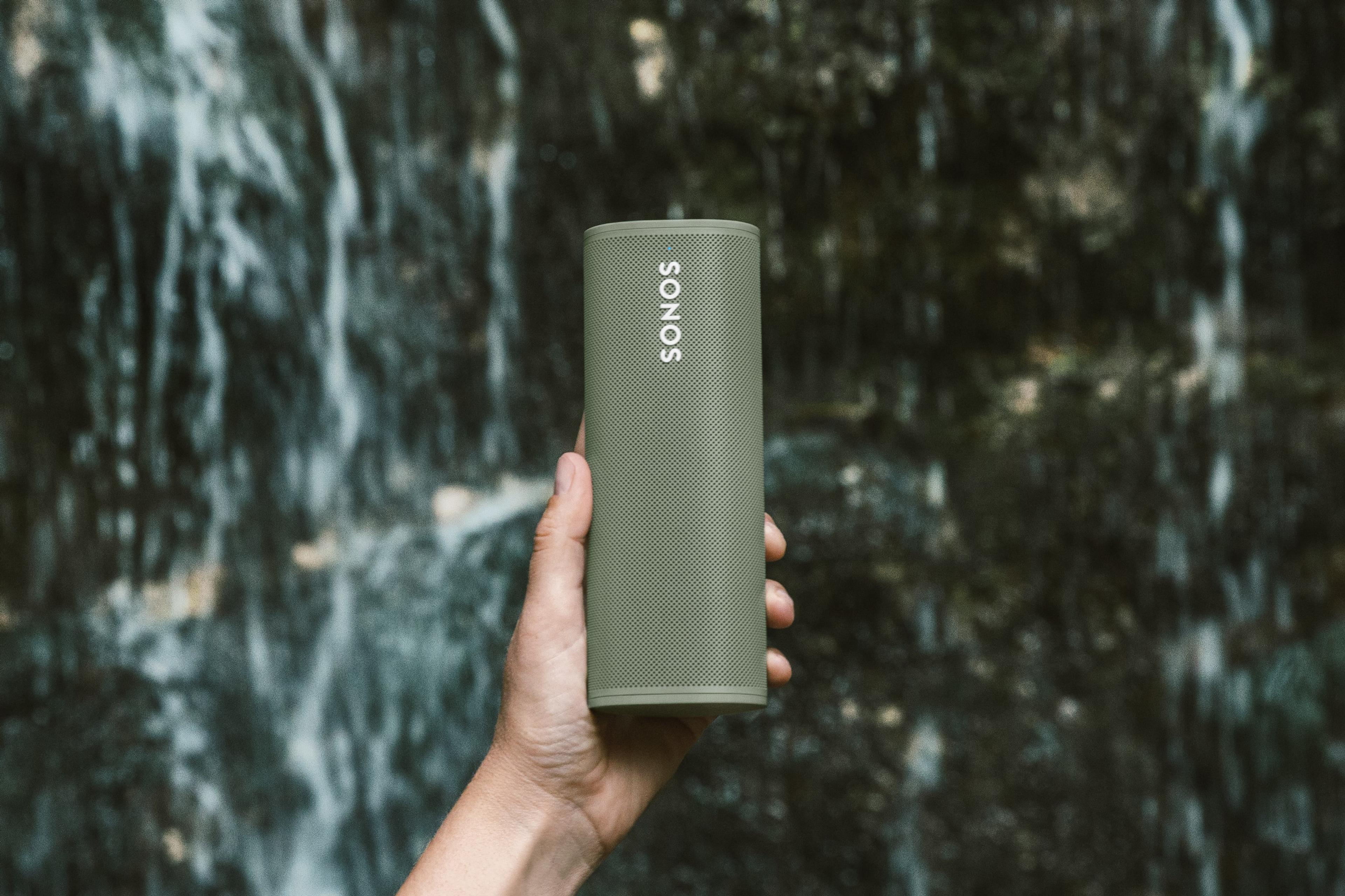 Roam-speaker in Olive wordt buiten gebruikt bij een waterval