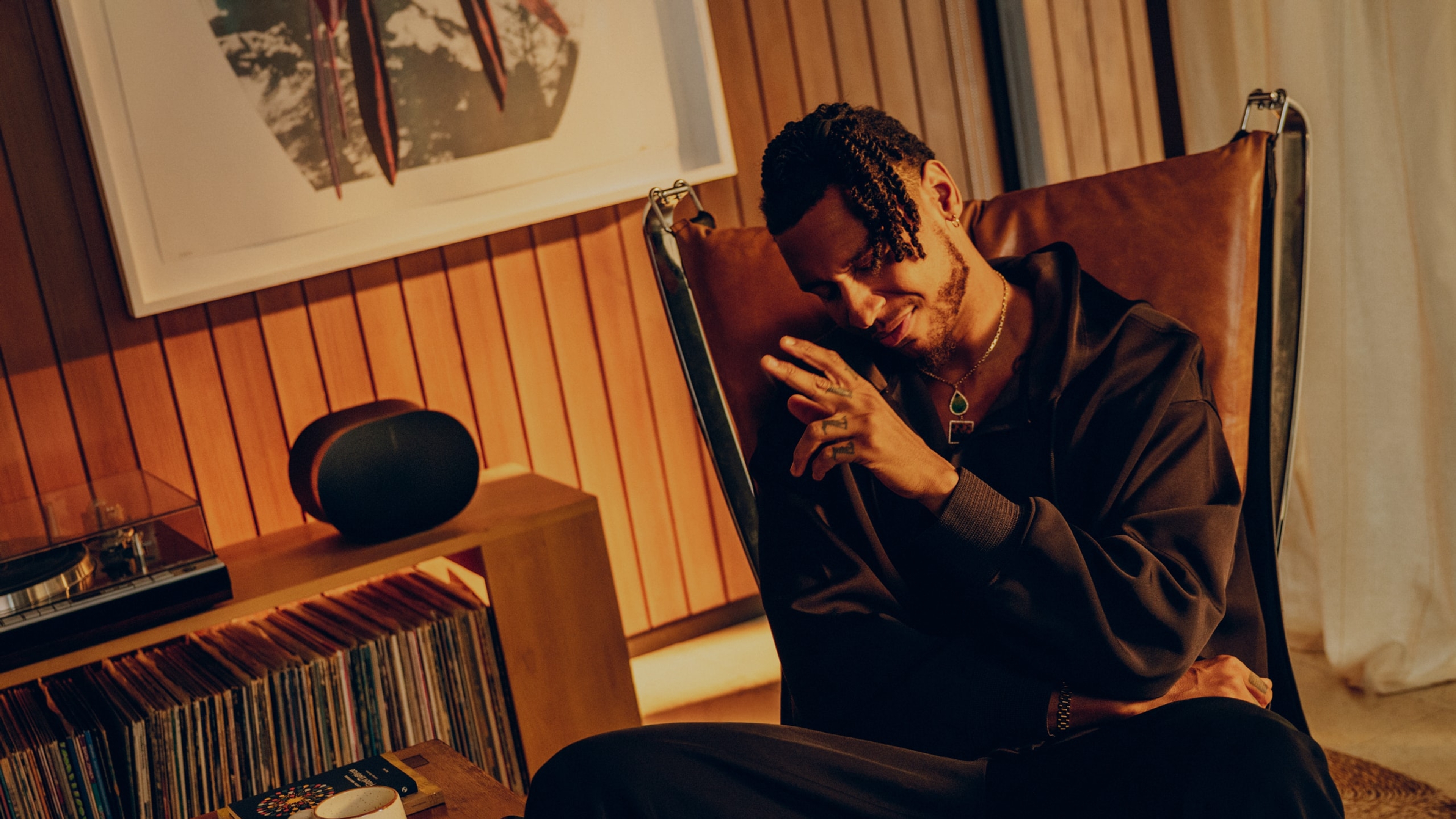 Musician and singer Masego listening to vinyl in his living room on a black Sonos Era 300 speaker