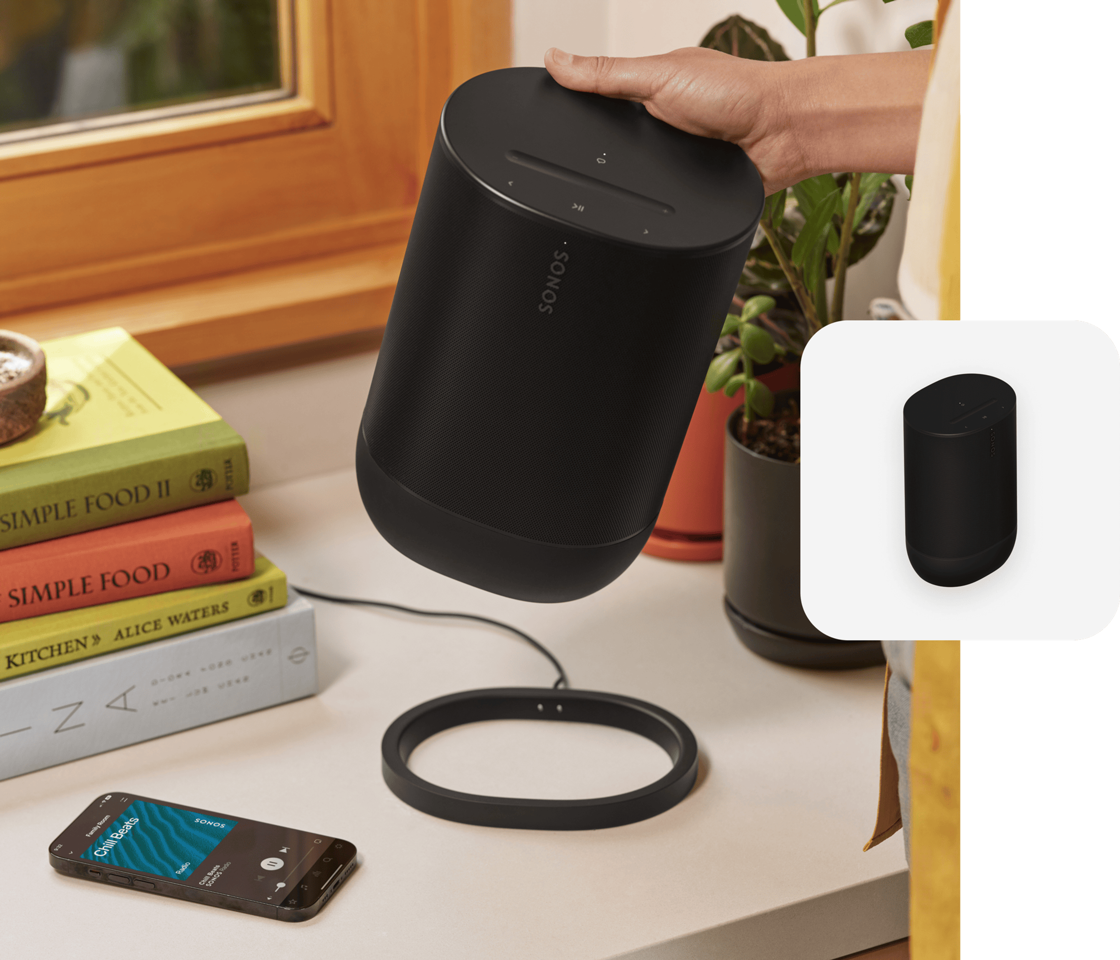 User in the kitchen removing a black Move 2 from its charging base